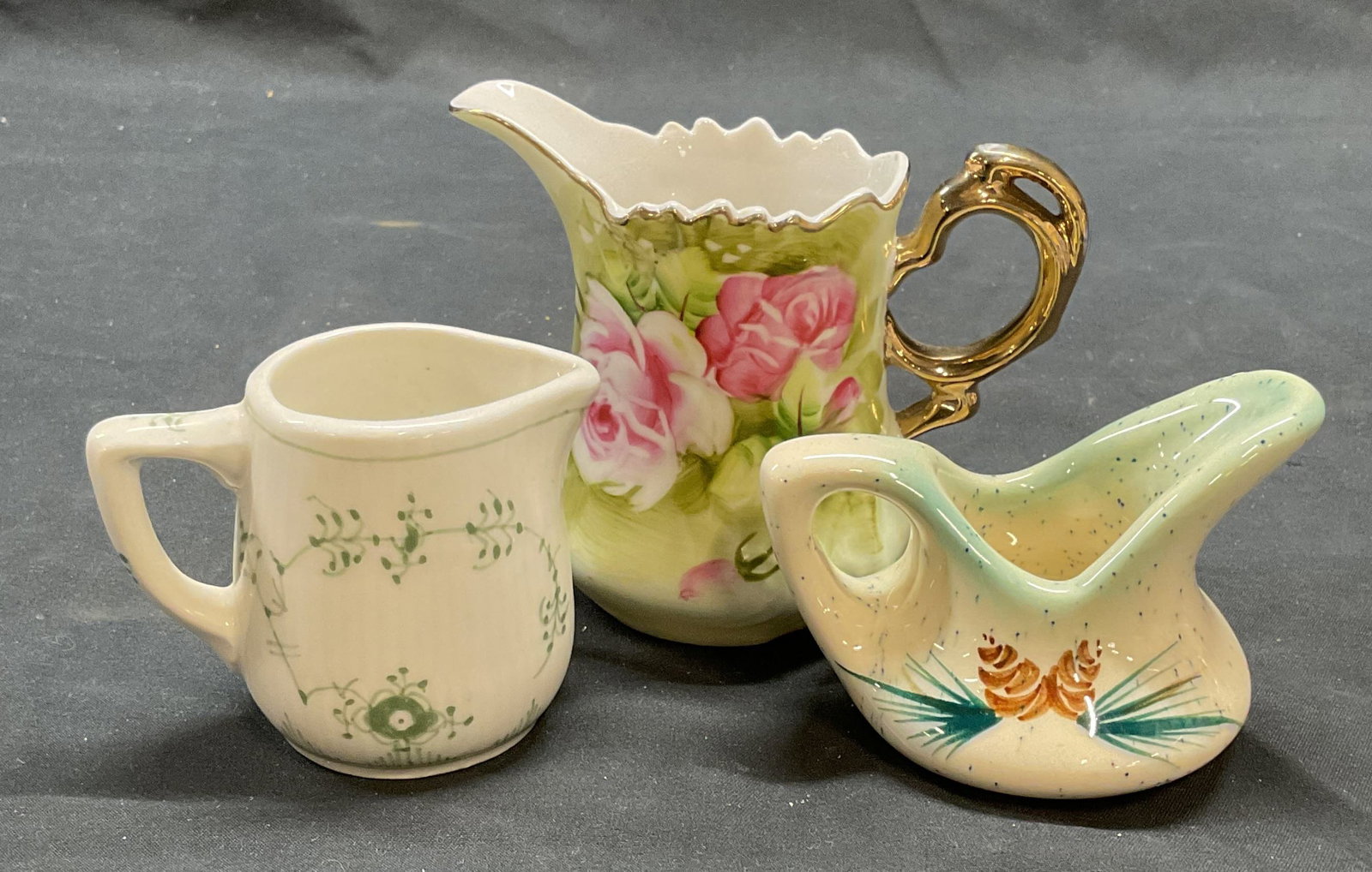 Lot 3 Royal Copenhagen Porcelain Creamer +: Lot of 3 porcelain and ceramic creamers. Royal Copenhagen lace pattern creamer in green and white. Signed porcelain creamed with hand painted floral motif in green. Signed ceramic creamer with hand pa