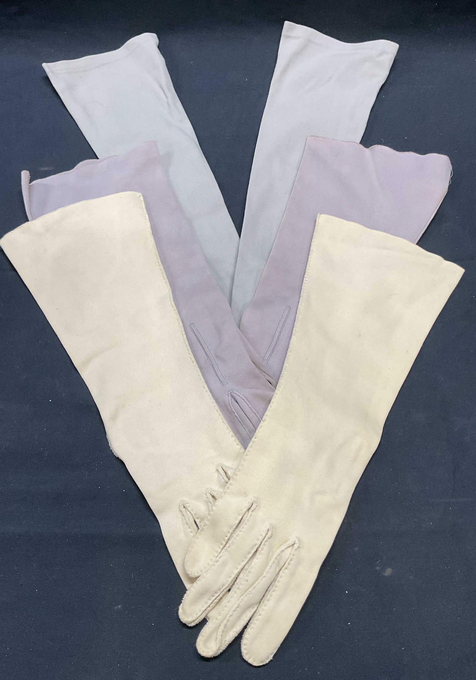 Lot 3 Vtg Shalimar Beige Cotton Gloves +: Lot of 3 pairs of vintage cotton and synthetic gloves in beige and grey. Beige cotton Shalimar gloves. Grey cotton and synthetic gloves. Longest pair measure approx. 17.5 inches. All pieces have some 