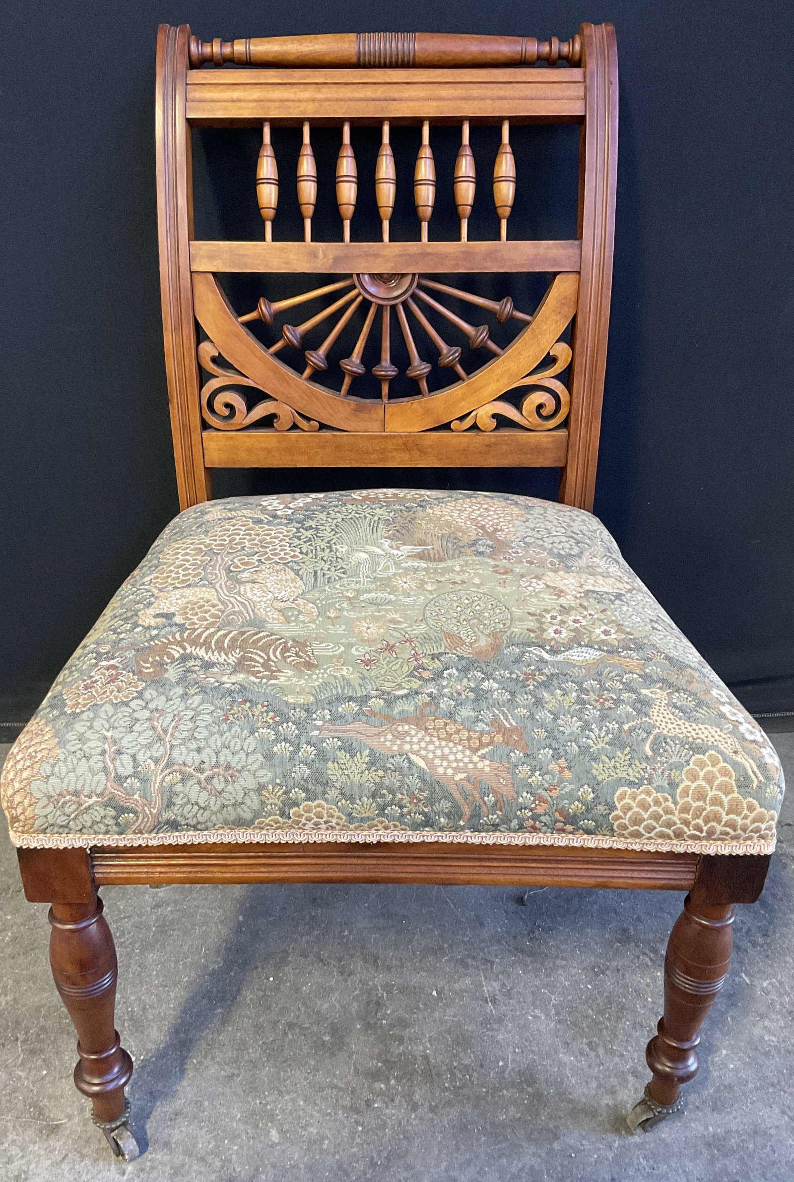 Vintage Jungle Motif Upholstery Chair On Casters: A vintage jungle motif upholstery side chair with an open woodwork back. Carved details to the wood. Casters to the two front feet. Measures approx. 32H x 20.5W x 18D in. Chipping, discoloration, and 