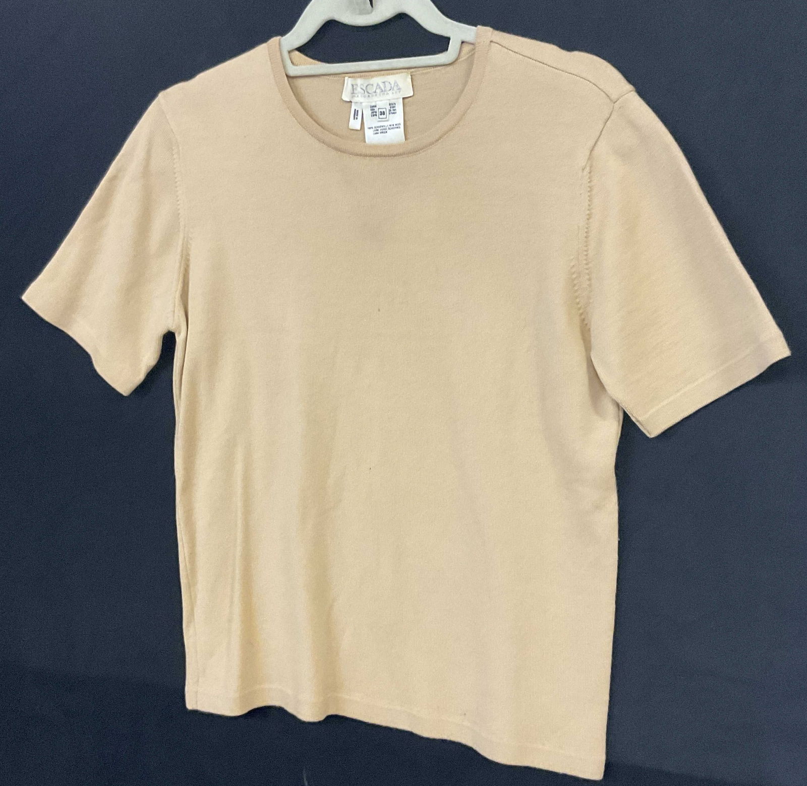 ESCADA Merino Extrafine Wool Shirt, Hungary: ESCADA Merino Extrafine Wool Shirt. Beige neutral hue. Material tag reads MERINO WOOL. Size tag reads 38. Length measured flat approx. 23.5 inches. Holes present. Surface wear and discoloration presen