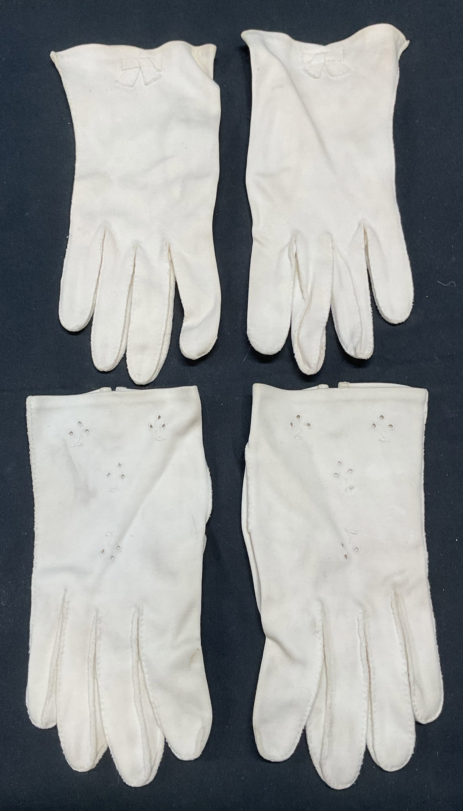 Lot 2 Vtg White Cotton Bow & Eyelet Gloves: Lot of 2 pairs of vintage white cotton gloves. Eyelet detail and bow detail. Longer pair measure approx 8.25 inches long. Gloves, vintage gloves, white gloves, cotton gloves, accessories, fashion acce