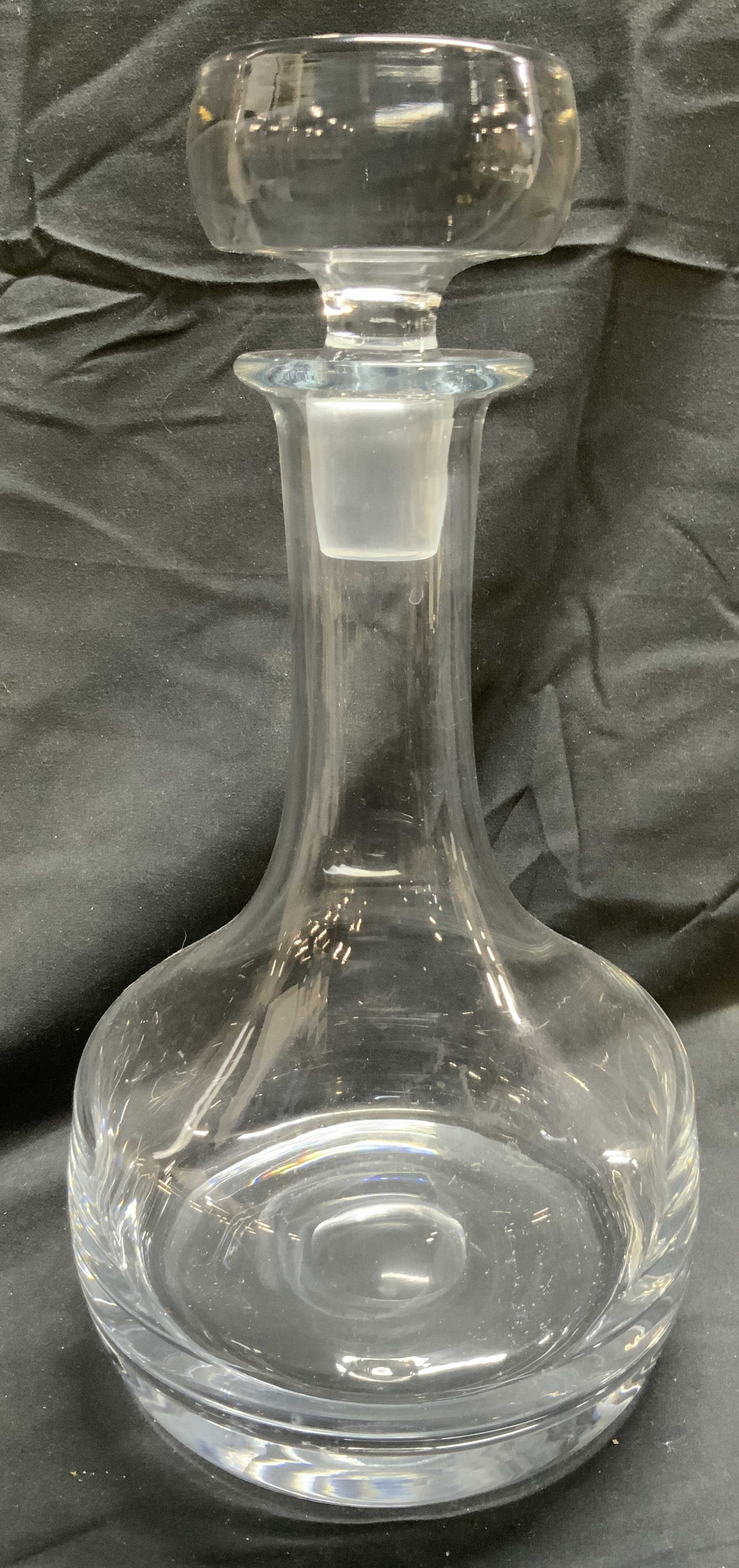 Art Glass Decanter W Stopper: Decanter is glass. Piece includes stopper. Decanter has thick walled floor. Decanter rim leans outward. Underside has pontil. Decanter measures approximately 11.5 inches tall 6 inches wide. Decanter, 