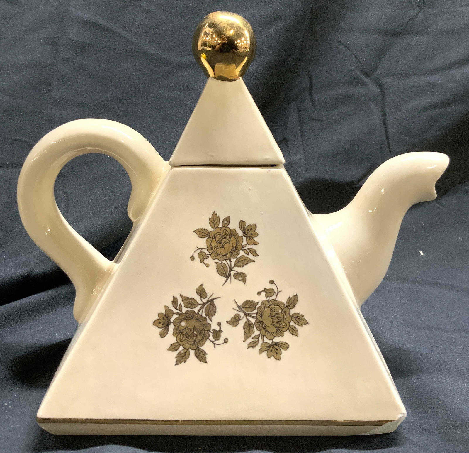 Vintage Porcelain Pyramid Form Coffee Pot W Lid: Coffee pot is vintage and porcelain. Piece is cream toned with gilt floral and leaf detail. Coffee pot includes lid. Lid has gilt spherical form handle. Vessel with lid measures approximately 7.5 inch