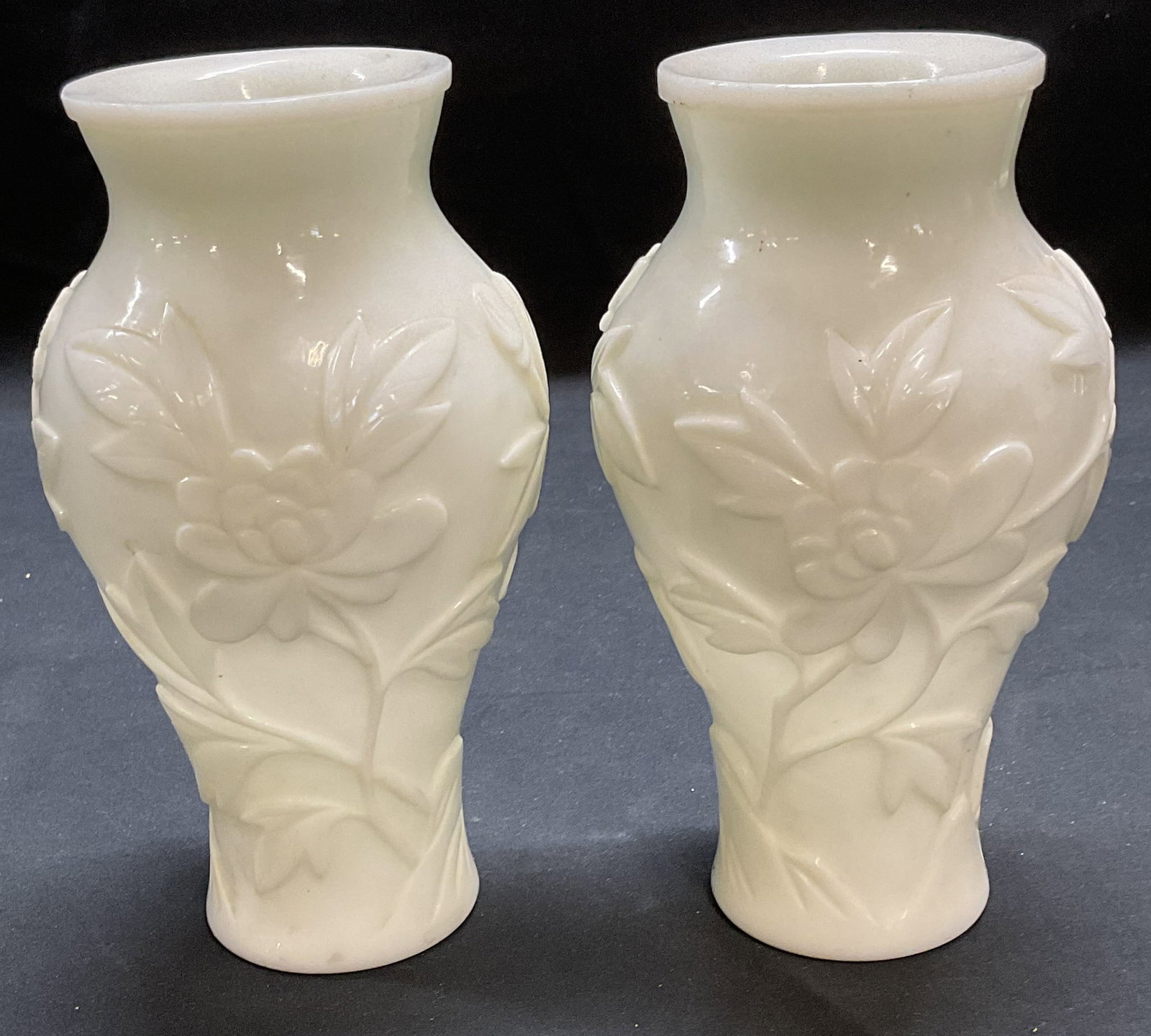 Pair Vtg Chinese Milk Glass Floral Vases: Pair of vintage Chinese milk glass vases with raised floral patterns. Measure approx. 3.5 x 6.5 inches each. Thick walled glass. Drainage holes on bases. Some surface wear to each including scratching