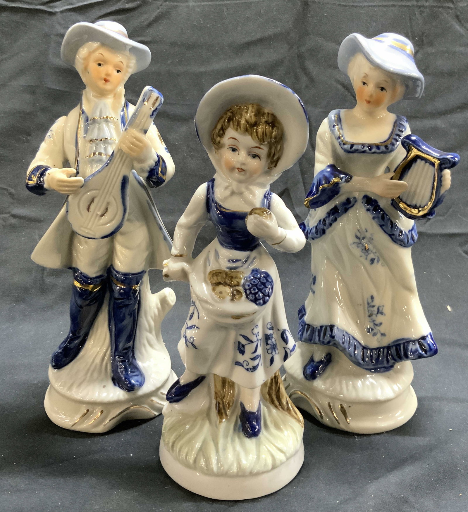 Lot 3 Vtg Male Female & Child Porcelain Figures: Lot includes 1 male, 1 female, & 1 female child figure. Each piece is vintage and porcelain. Adults figurals are depicted playing instruments. Largest figurals measure approximately 8 inches tall 3.5 