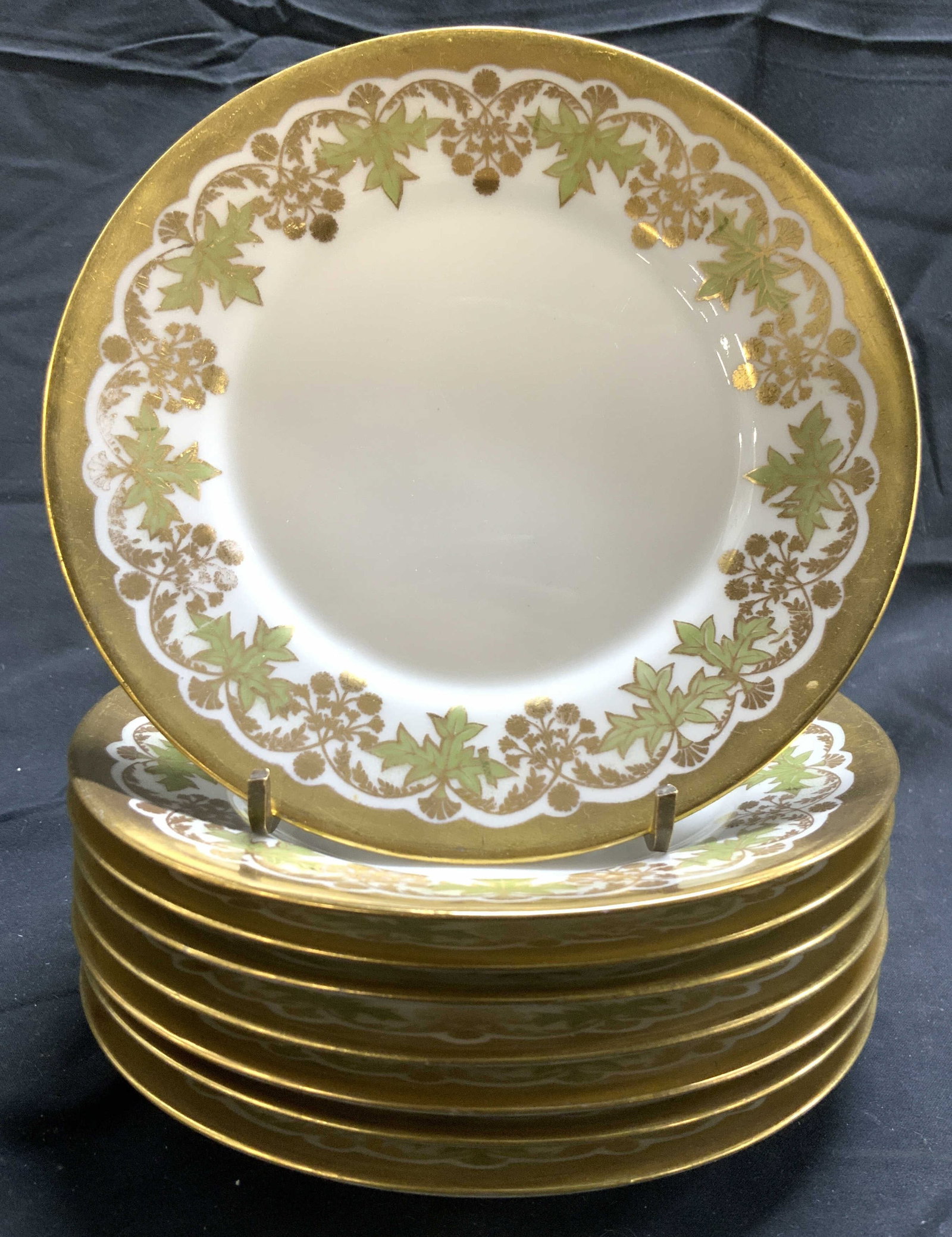 LIMOGES FRANCE Set 8 Vntg Gilt Porc Plates: Undersides are marked LIMOGES FRANCE. Lot includes 8 plates. Each piece is porcelain, appears to be vintage. Plates are white with gilt rims, floral, leaf & vine detail. Each plate measures approximat