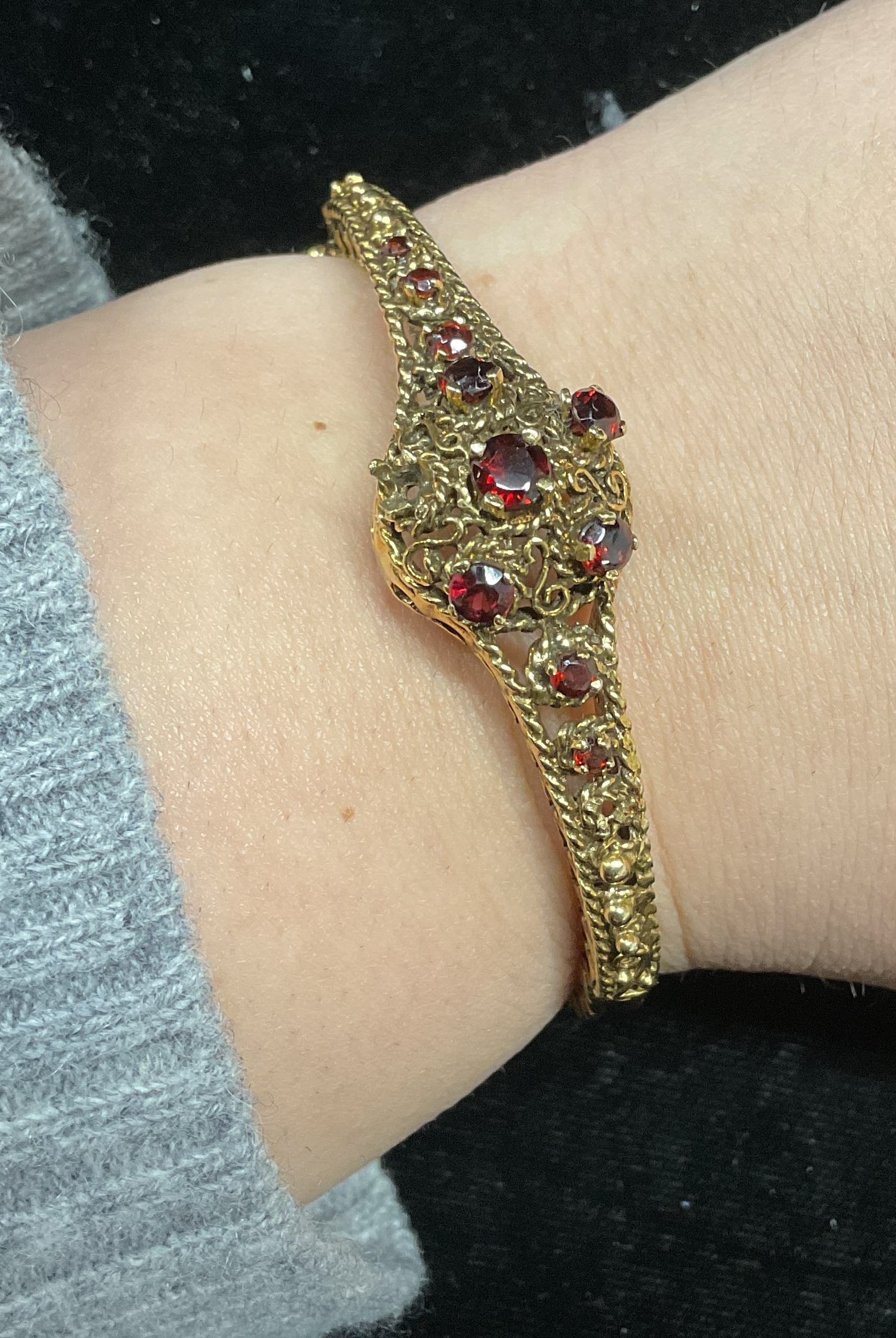 Vintage Garnet Semiprecious Bracelet: Vintage hinged bracelet with garnet semiprecious stones. Possibly gold vermeil over sterling. Not tested. Partial marking observed, illegible. Measures approx. 2 inches wide. Some garnet needs replace