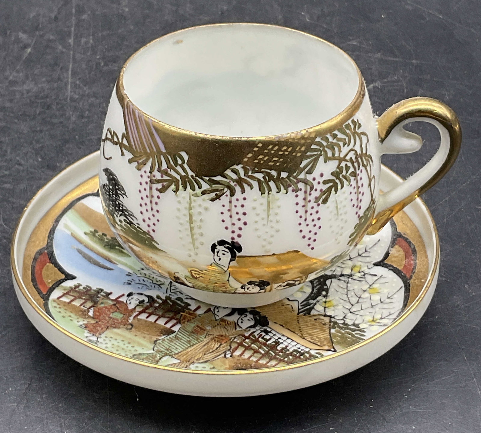 KOSHINDA Vtg Hand Painted Porcelain Cup & Saucer: KOSHINDA Signed Vintage Hand Painted Porcelain Demitasse Cup & Saucer. Demitasse cup measures approx. 2H x 3W in. Width includes handle. Multicolored hues throughout. Figural motifs in nature settings