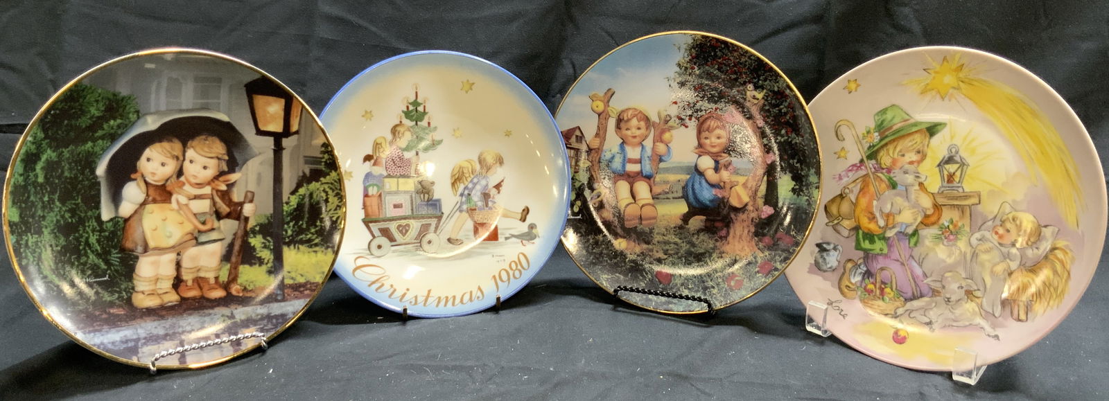Lot 4 German & Swiss Porc Plates GOEBEL & More: Lot Includes 4 plates. Each are porcelain. Lot includes 1 trademarked SCHMID, 1 trademarked GOEBEL, & 2 trademarked MJ HUMMEL. Each have various depictions of children. Hummel plates have gilt rims. L