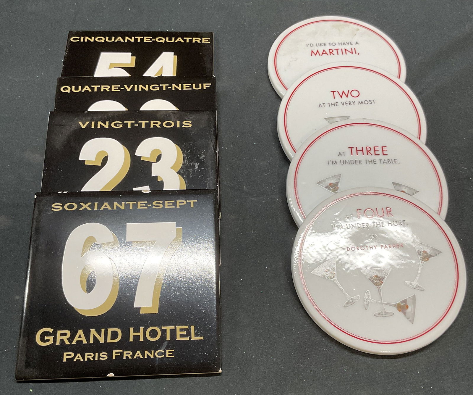 Group Lot Martini, Paris Hotel Coasters: Group lot of 4 Grand Hotel Paris ceramic coasters and 4 Dorothy Parker Martini motif ceramic coasters. Larger measure approx. 4.25 x 4.25 inches. All pieces have some wear including chips observed. Co