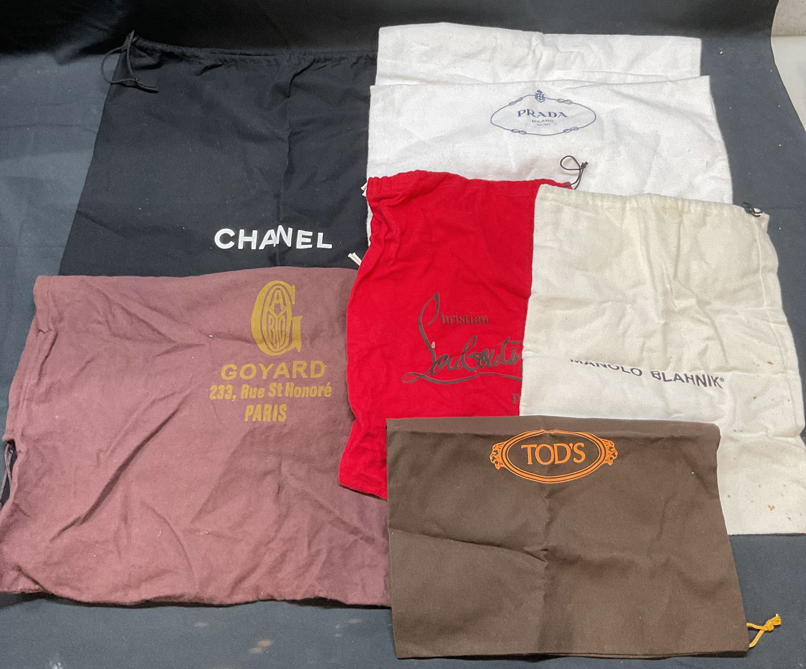 Group Lot Luxury Designer Dust Bag, Chanel +: Group lot of luxury designer dust bags. Includes Chanel, Prada, Goyard, Christian Louboutin and more. Largest measures approx. 22 x 18 inches (Chanel). All pieces have some wear to materials consisten