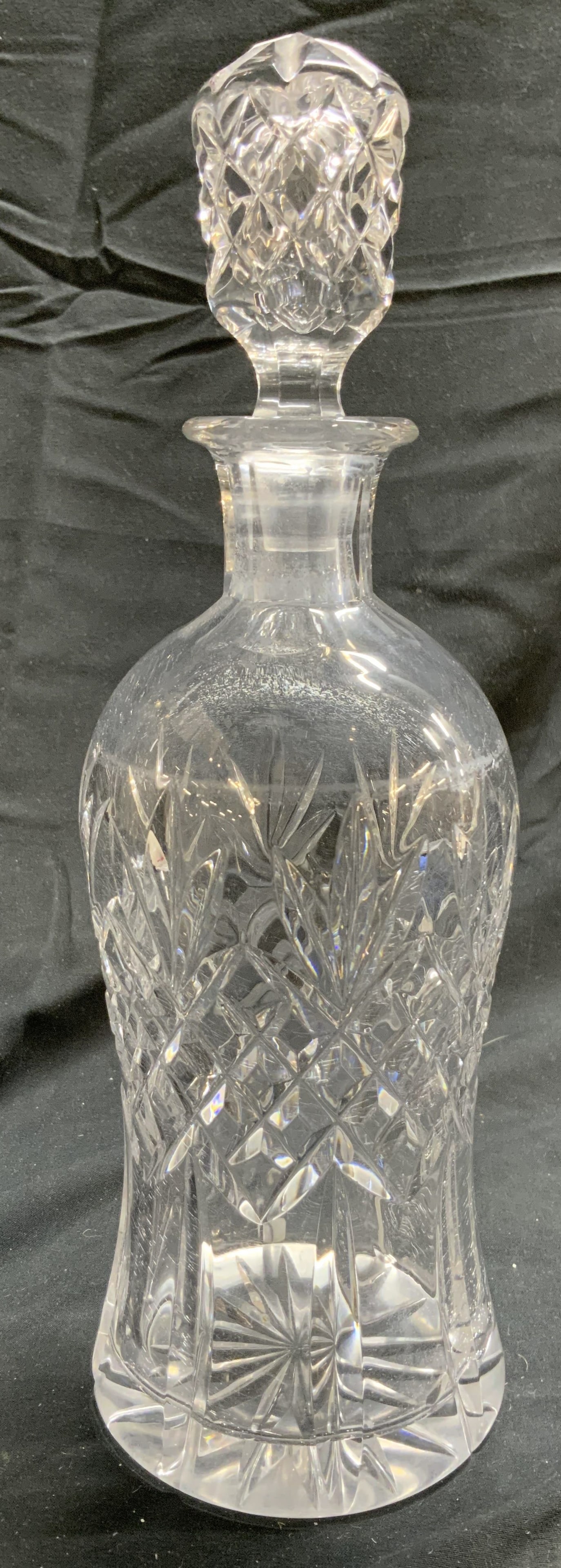 Crystal Art Glass Decanter w Stopper: Decanter is crystal. Piece has diamond form relief pattern detail. Decanter includes stopper. Piece has thick walled base. Decanter with stopper measures approximately 11 inches tall 3.75 inches wide.