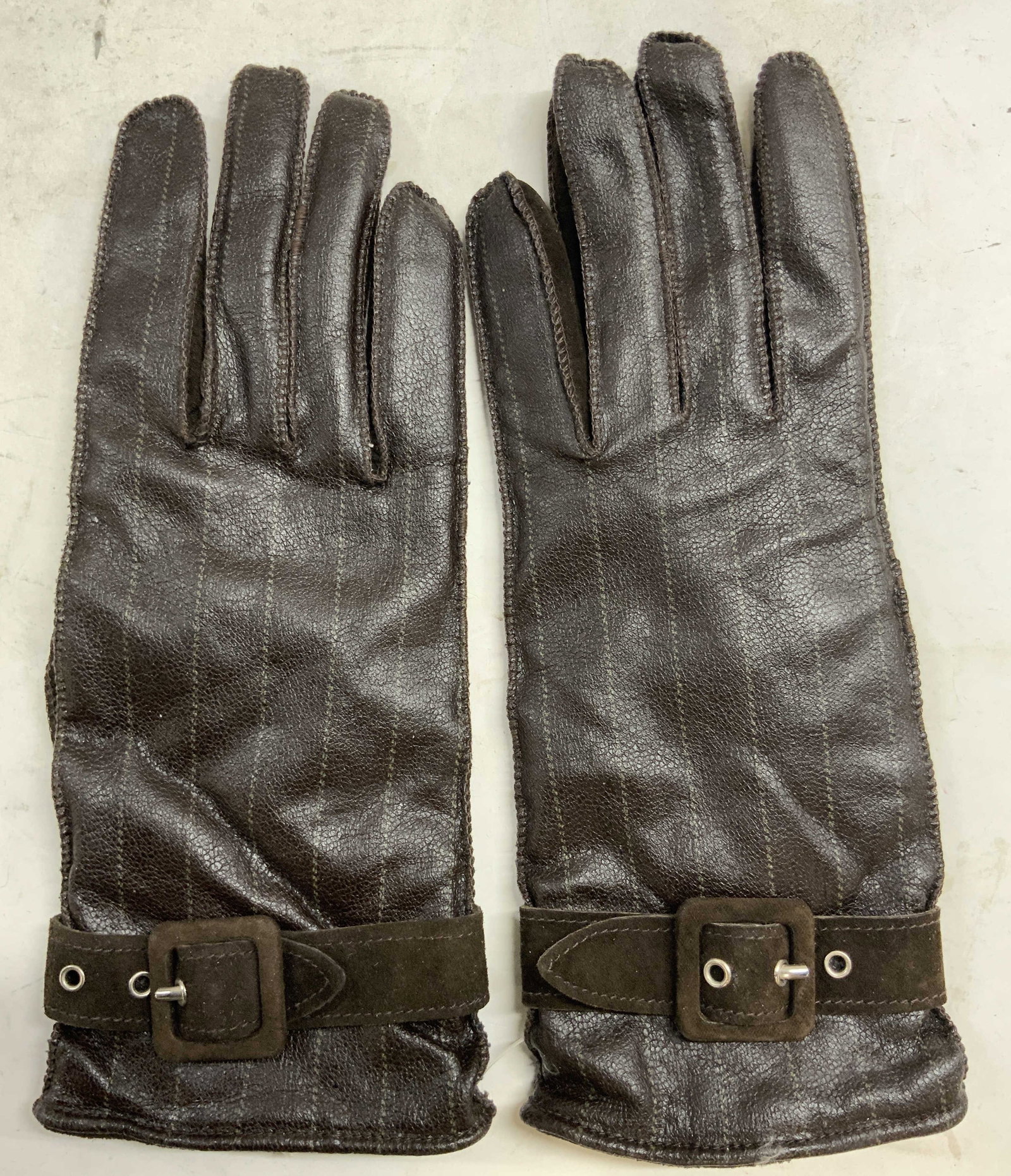 GILMAR Pr Leather & Cotton Gloves Brown ITALY: Tag on interior reads GILMAR ICEBERG JEANS, LEATHER, COTTON, POLYURETHANE. Lot includes 1 pair of gloves. Each are brown toned with straps at wrist areas. Each glove measures approximately 9.5 inches 