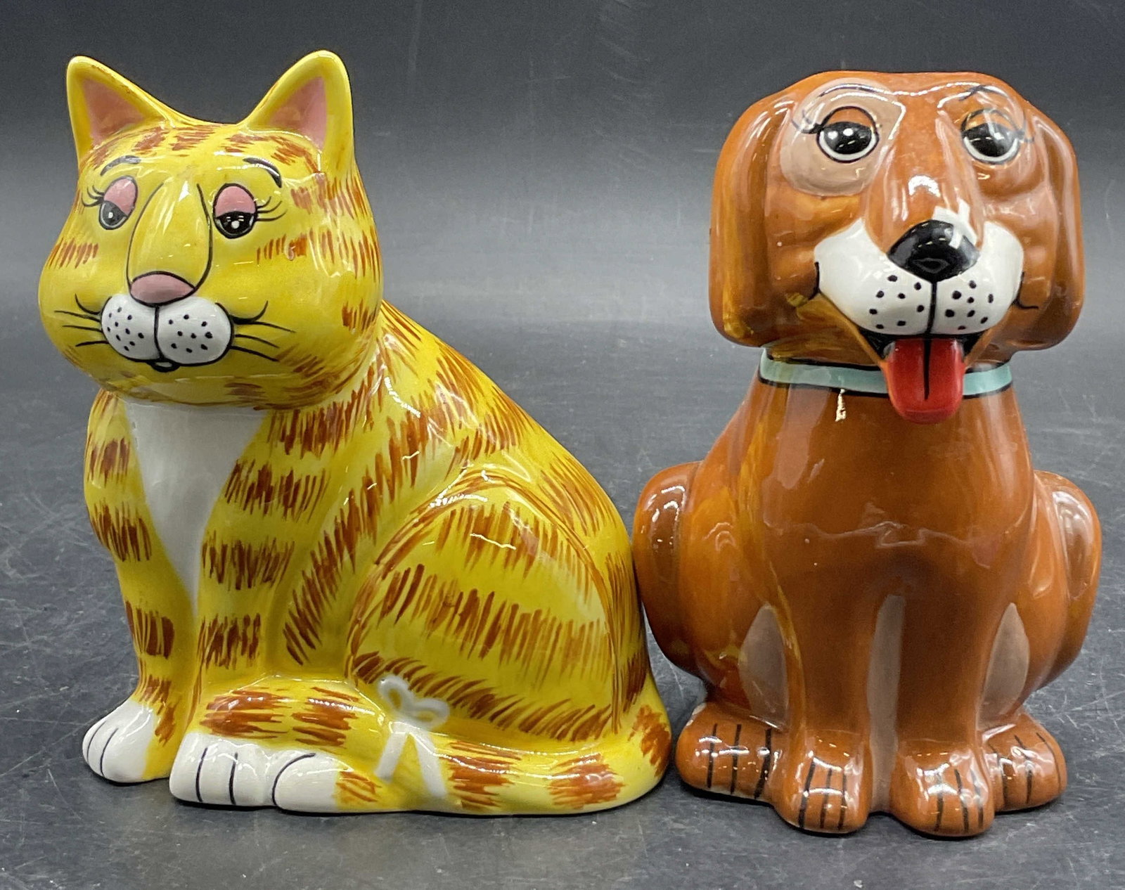 Set GARY PATTERSON Ceramic Cat & Dog Shakers: A set of GARY PATTERSON Ceramic Cat & Dog Shakers. Salt and pepper shakers in the form of a cat and a dog. Undersides are signed GARY PATTERSON, ALL RIGHTS RESERVED. The cat measures approx. 4H x 3.5W