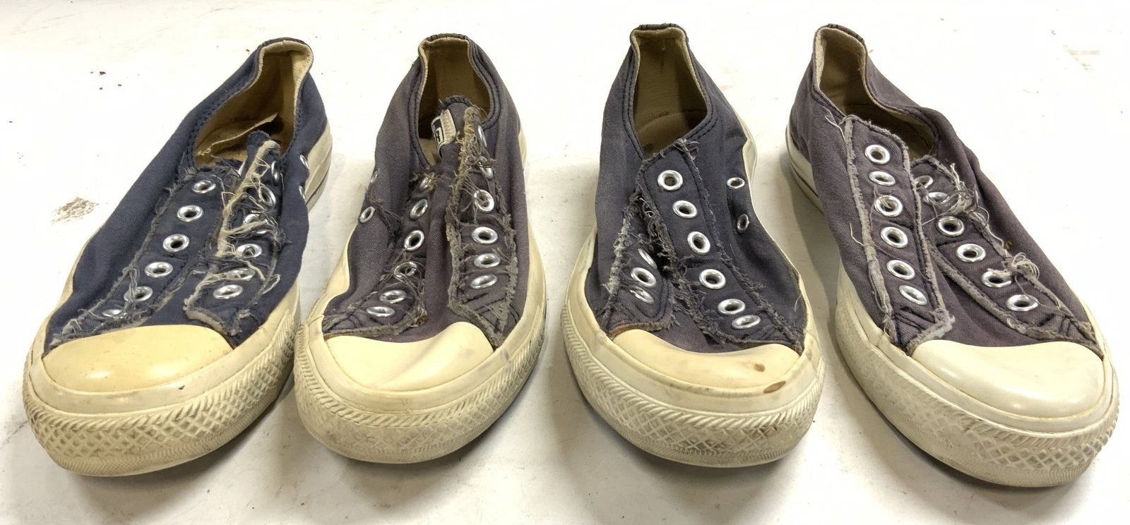 Lot 2 Pairs Of Womens Converse All Star Shoes 6: Each shoe is trademarked CONVERSE ALL STAR. Lot includes 2 pairs of shoes. Each shoe is faded navy toned with cream toned mid soles, brown toned undersides. Shoes have silver toned eyelets. Each shoe 