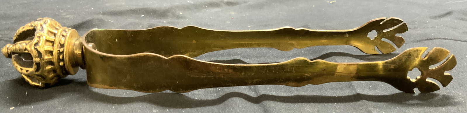 Solid Brass Ice Tongs W Crown Structure: Ice tongs are gold toned, appear to be solid brass. Piece has claw form ends. Top of tongs have crown form. Ice tongs are vintage. Piece measures approximately 8 inches long 2.25 inches wide. Ice tong