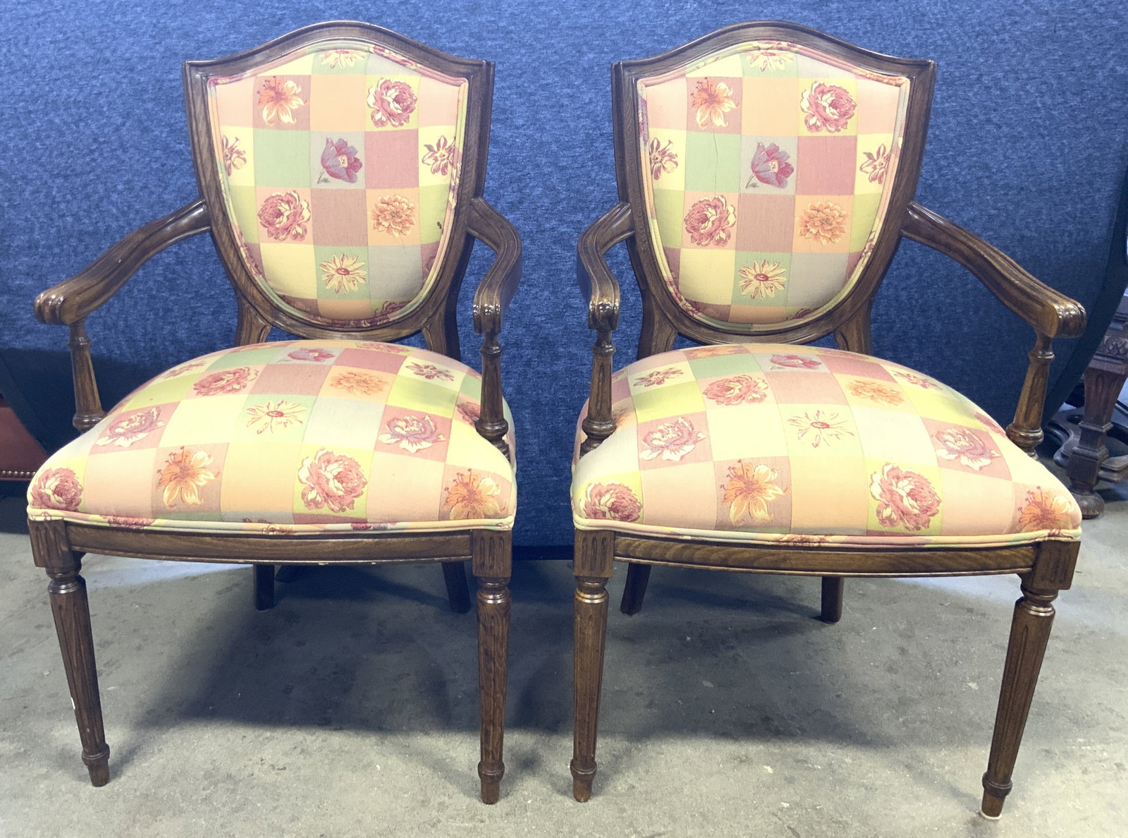 Pr Vtg Uph Wooden Country French End Chairs: Lot includes 2 end chairs. Each appear to be country French. Chairs each have shield form backrest. Each chair has multi toned checkered and floral detail. Edges of chair upholstery has double welting