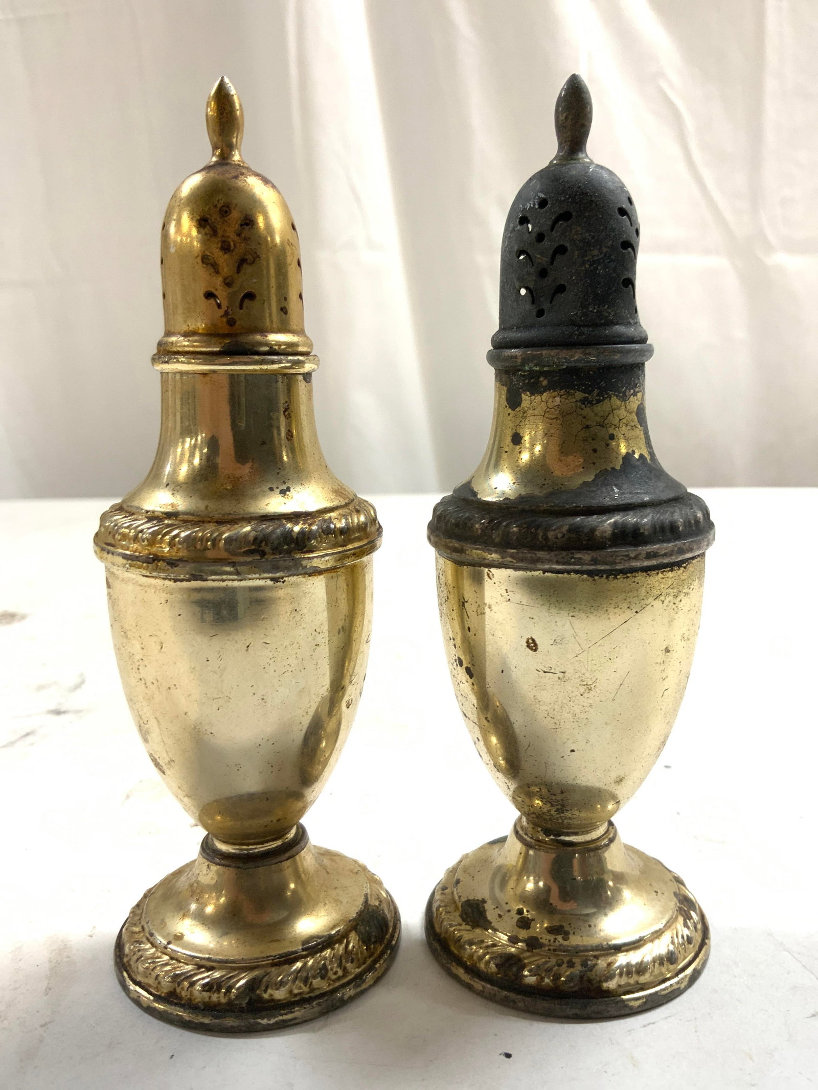 CORNWELL Sterling Silver Salt & Pepper Shakers: Undersides are inscribed CORNWELL STERLING WEIGHTED REINFORCED. Lot includes 2 shakers. Each have pierced detail at top. Shakers are footed. Each measures approximately 5 inches tall 1.75 inches wide.