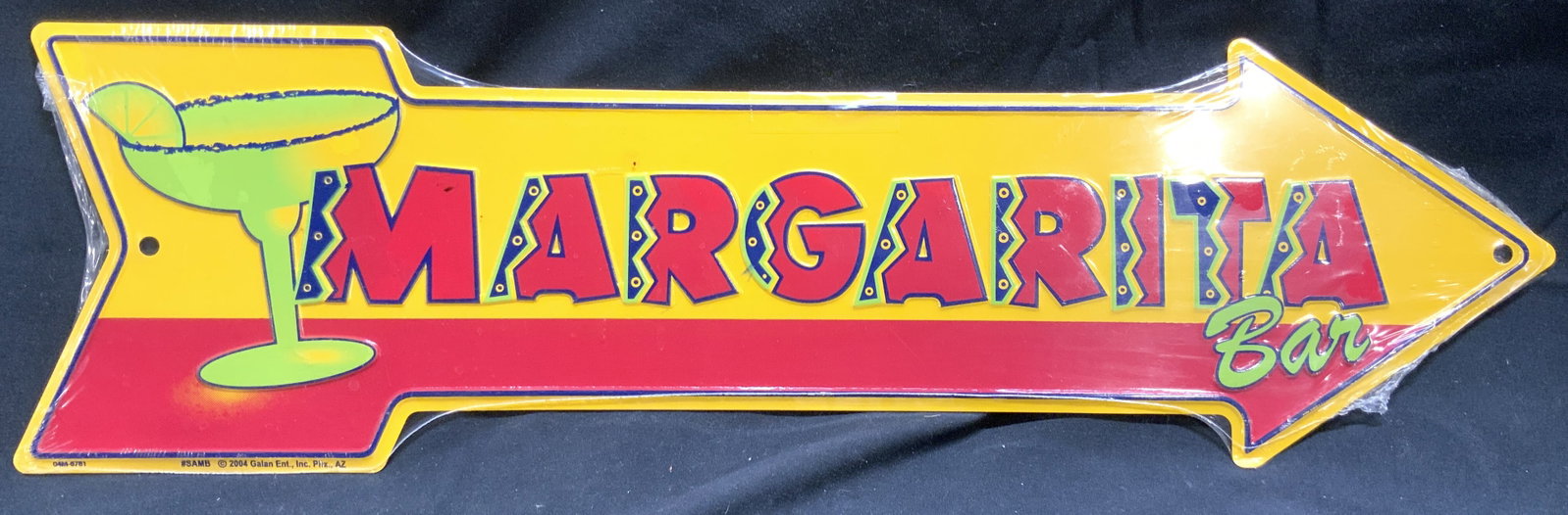 GALAN ENT INC Margarita Bar Metal Arrow Sign: Sign is trademarked GALAN ENT INC. Sign reads MARGARITA BAR. Piece is metal. Sign has arrow form. Piece has yellow, navy, green & red tones. Piece in original packaging. Sign measures approximately 19