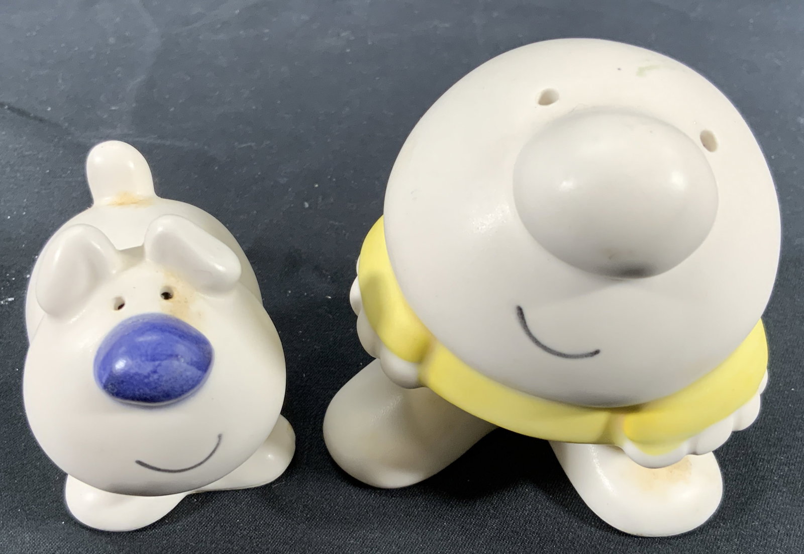 Vintage Ziggy & Dog Salt & Pepper Shakers: Ceramic slat & pepper shakers. Shakers depicts Ziggy and his dog from the American cartoon series Ziggy. The eyes are the holes for the salt and pepper. Undersides have copyright stickers. Ziggy measu