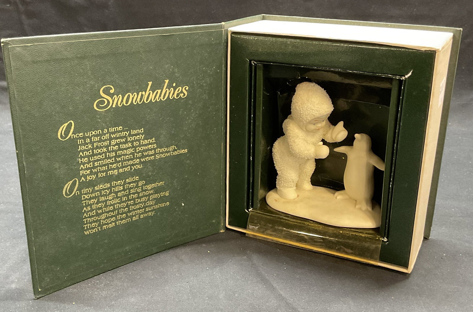 Department 56 Porcelain Snowbabies Figurine: Department 56 porcelain Snowbabies figurine. Baby with penguin. Signed on underside. Includes box. Figurine measures approx. 4 inches tall, 3.75 inches wide. Box measures approx. 6.5 x 6 x 3 inches. W