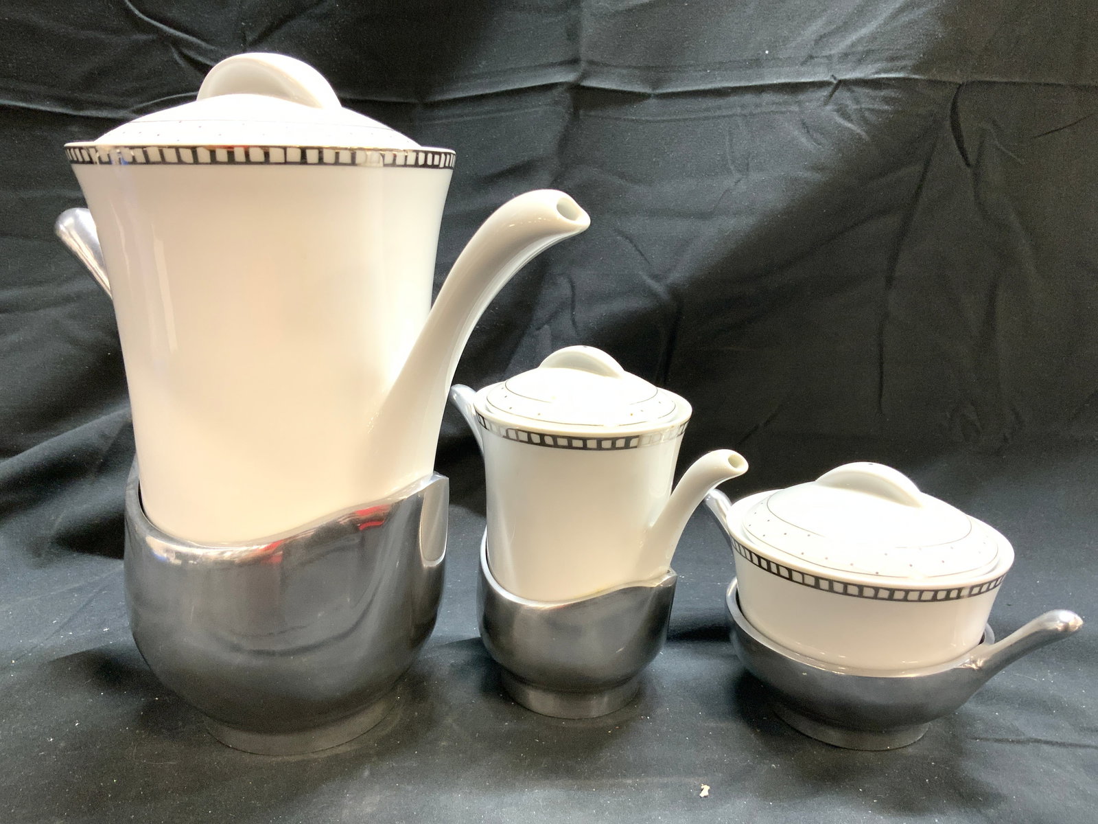 ICEBERG Set 3 Prc Coff Pot Creamer & Sugar Dishes: Underside of each piece is marked ICEBERG. Lot includes 1 coffee pot, 1 creamer dish & 1 sugar dish. Each piece in lot includes lids. Each piece is white toned and porcelain with pattern to outer rims