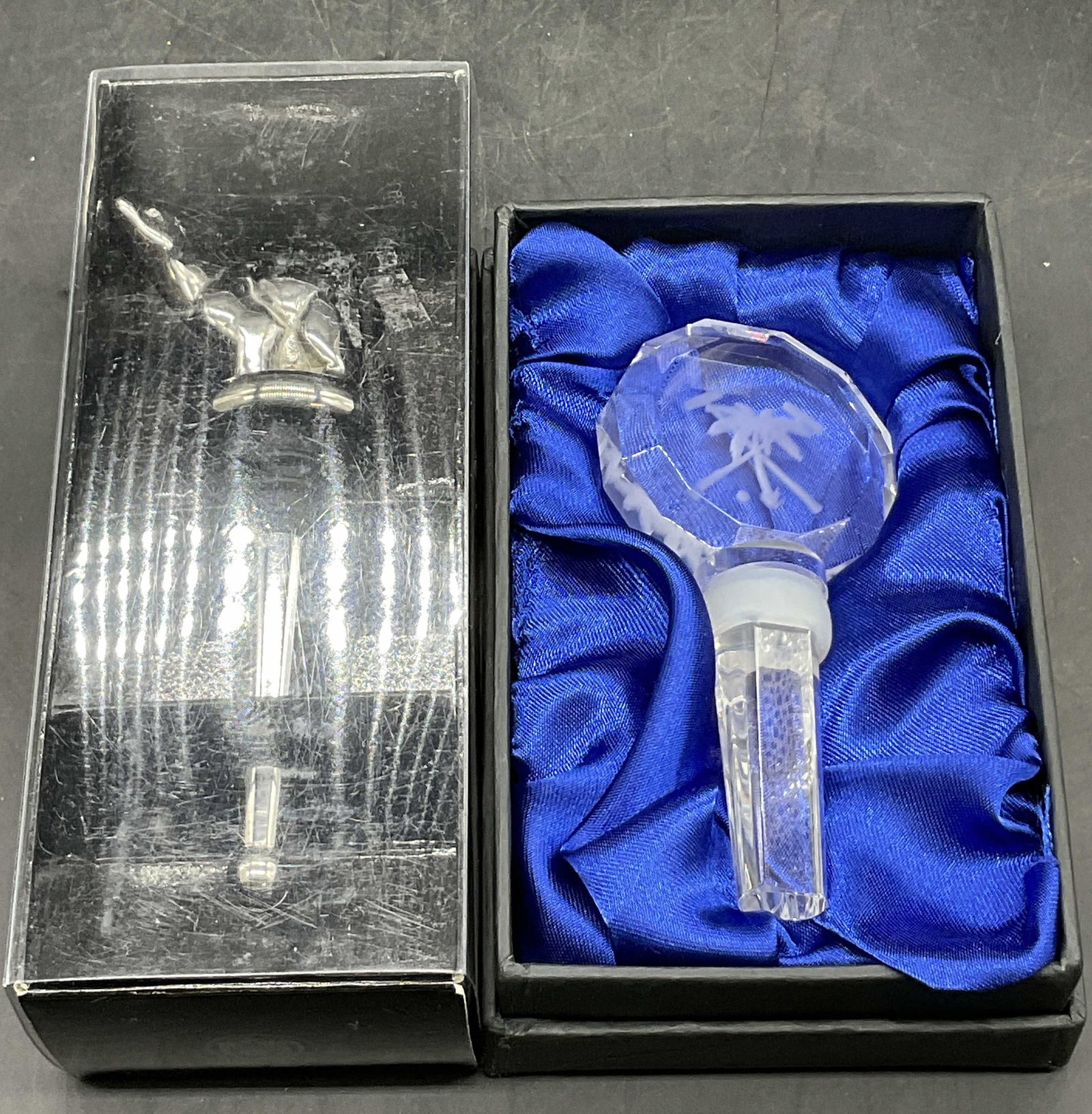 2 Stainless Steel & Glass Bottle Stoppers, Box: Two boxed bottle stoppers. One is crafted from stainless steel and features a polar bear figural. Measures approx. 6.25L x 2.5W in. Not examined out of package. The other is a packaged glass bottle st