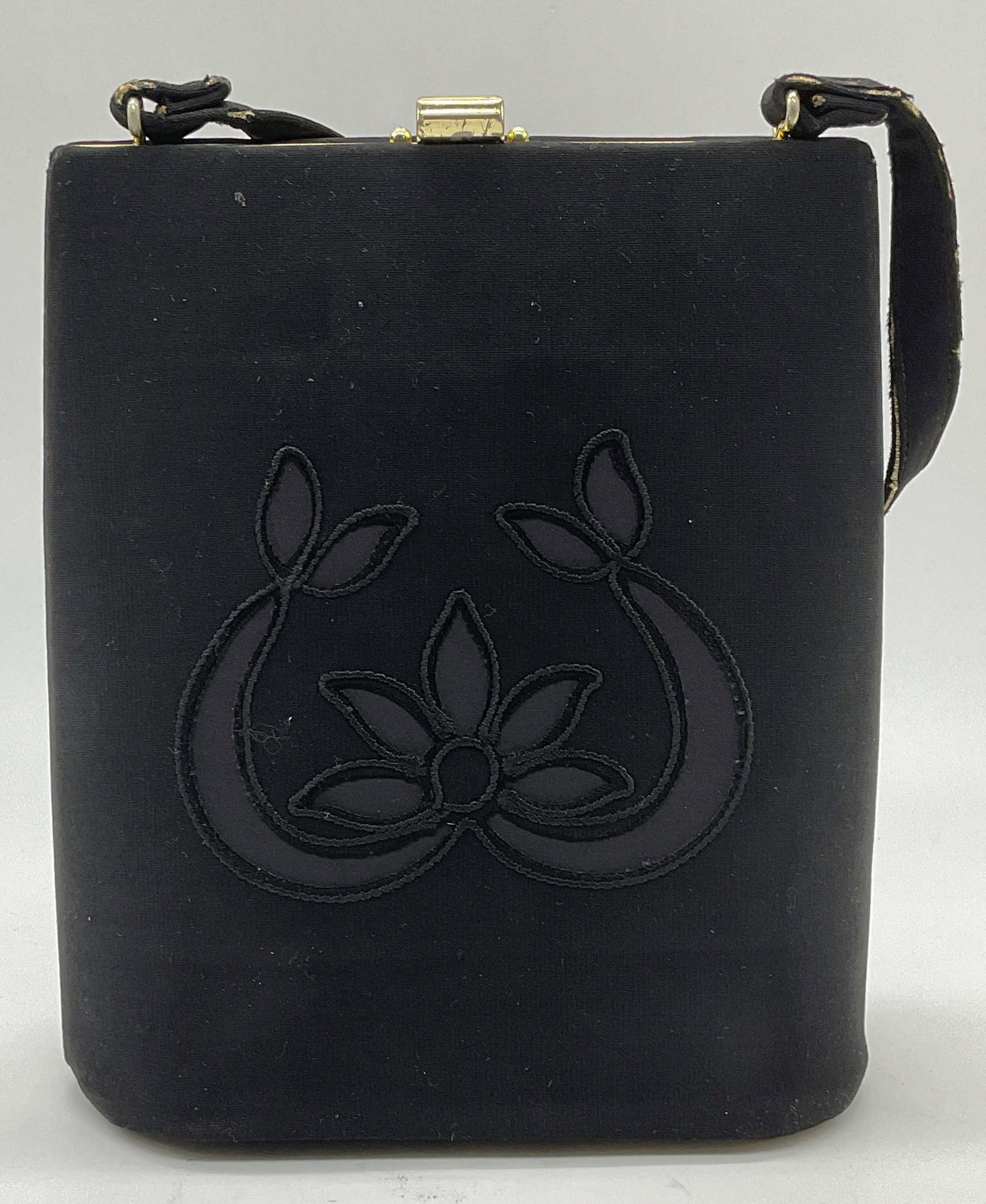 Vintage Black Satin Floral Handbag: Vintage black structured handbag with cloth and satin detail. Floral design. Gold tone hardware. Measures approx. 7 x 3 x 8.5 inches. Some wear including blemishes and tearing observed. Vintage handba