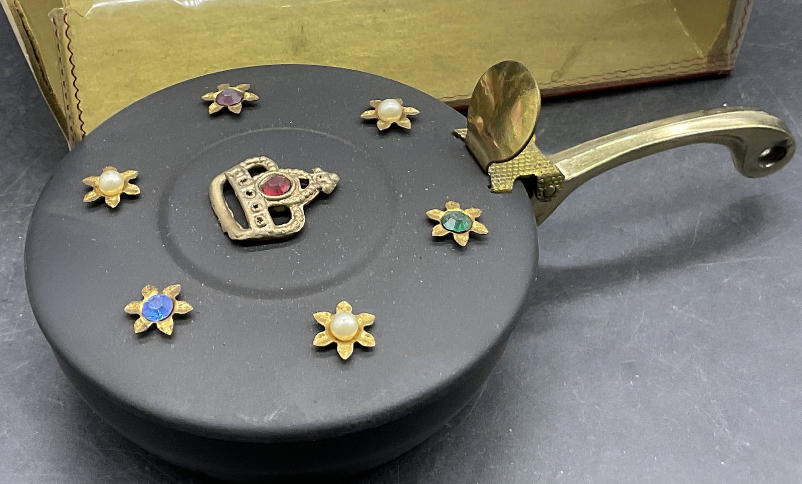 THE PRINCESS MINI BUTLER Crumb Catcher W/ Box: THE PRINCESS MINI BUTLER Crumb Catcher With Original Box. Packaging measures approx. 5.5W x 1.75H in. Packaging reads THE PRINCESS MINI BUTLER, MADE IN USA. The crumb catcher is studded with faceted m