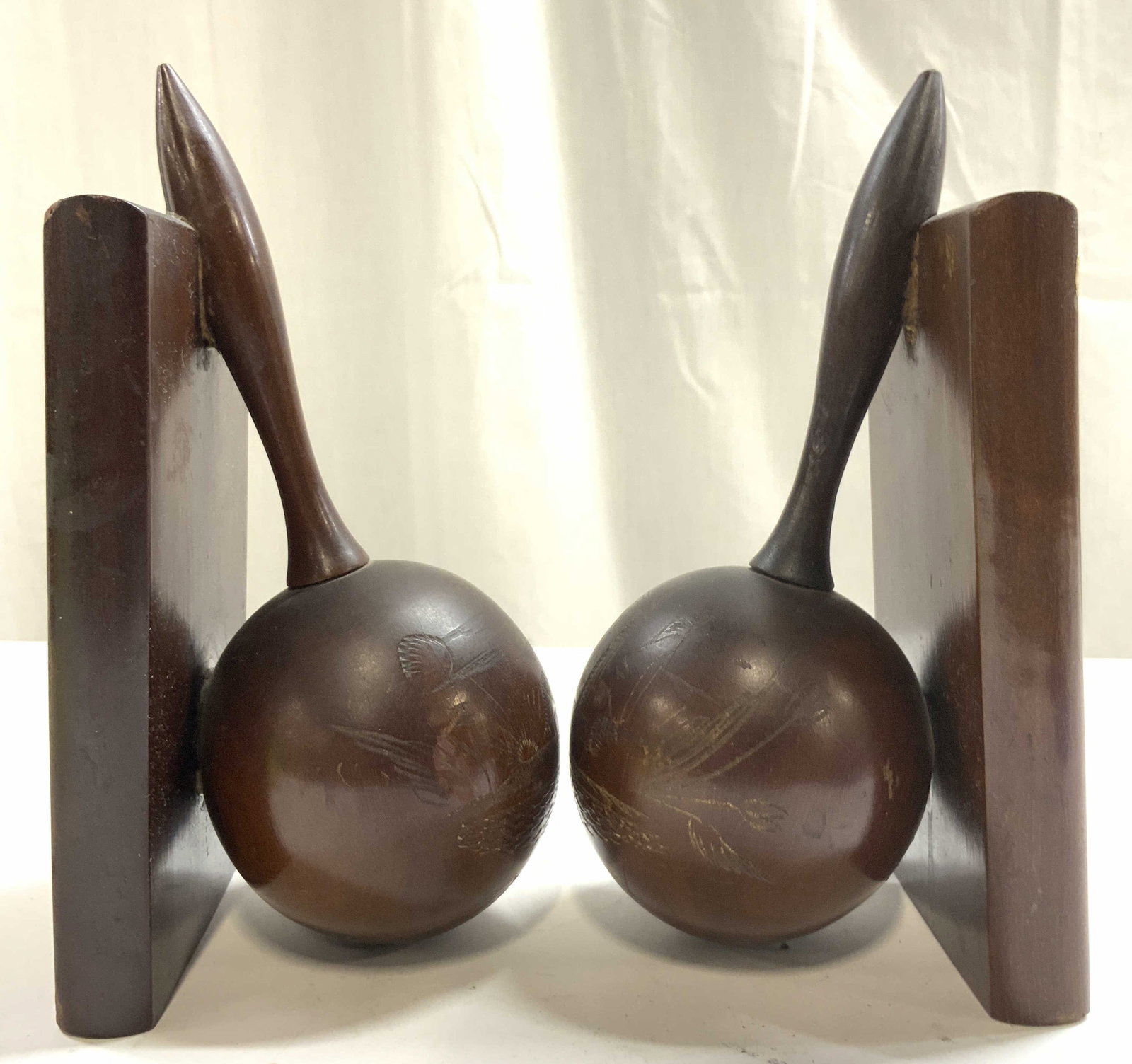 Pair Vtg Carved Wooden Maraca Bookends: Undersides inscribed MADE IN CUBA. Lot includes 2 bookends. Each are brown toned and wooden. Bookends each have maraca form. Each bookend has carved landscape relief detail. Bookends each measure appr