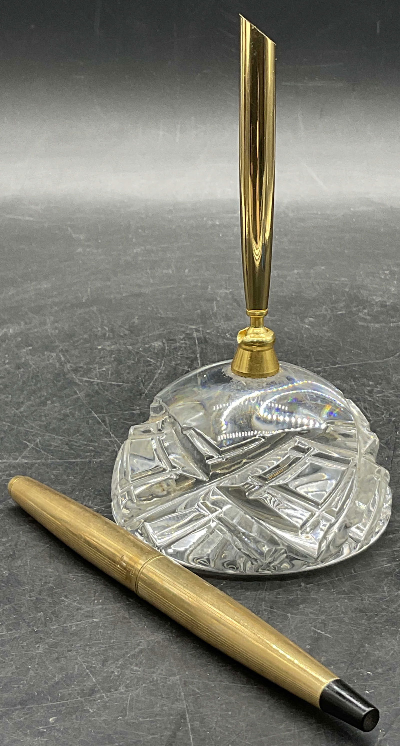Cut Crystal Desktop Pen Holder & Parker French Pen: Cut Crystal Desktop Pen Holder & Parker French Pen. Colorless crystal pen holder / paperweight has a gold tone metal adjustable embellishment for holding pens. Measures approx. 5.25H x 3W in. The pen