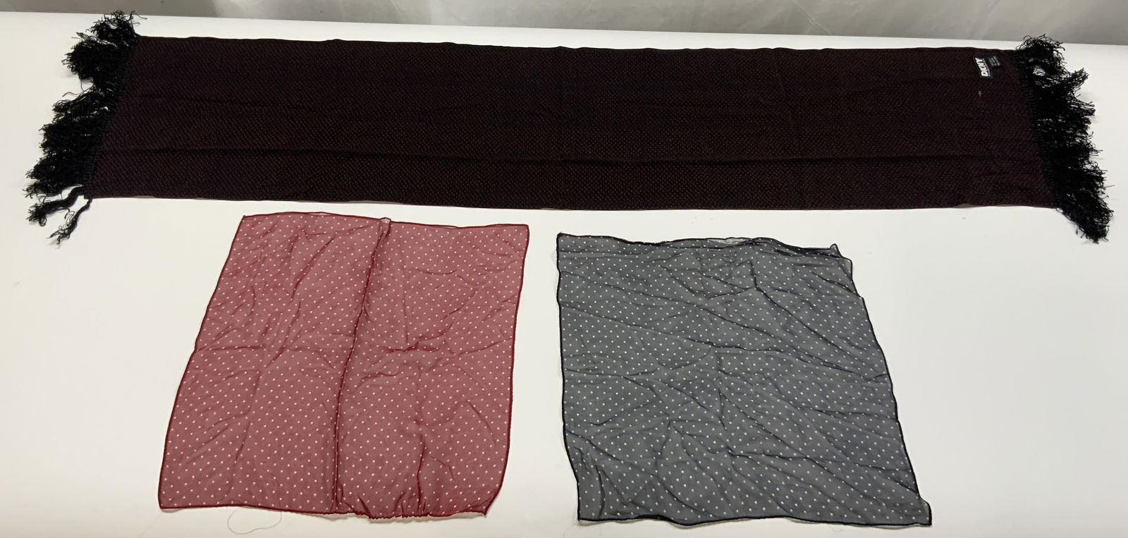 DKNY Fringed Silk Scarf & More: Tag in scarf reads DKNY 100% SILK. Scarf is black with red toned pattern detail. Lot also includes 1 red, & 1 navy toned pocket squares with white polka dot detail. Scarf measures approximately 52 inc