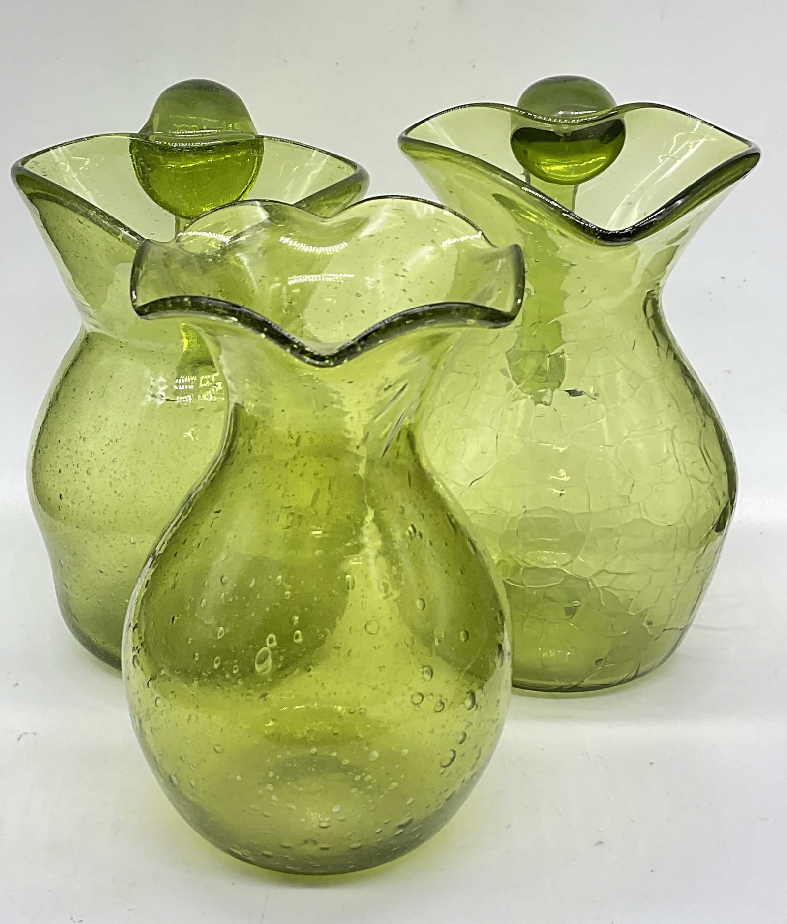 3 Vintage Handmade Green Art Glass Pitchers & Vase: Three Handmade Vintage Green Art Glass Pitchers & Vase. One piece has a crackle design. The other two pieces have bubbles to their design. Pieces are similar in size, tallest measures approx. 5H x 4W 