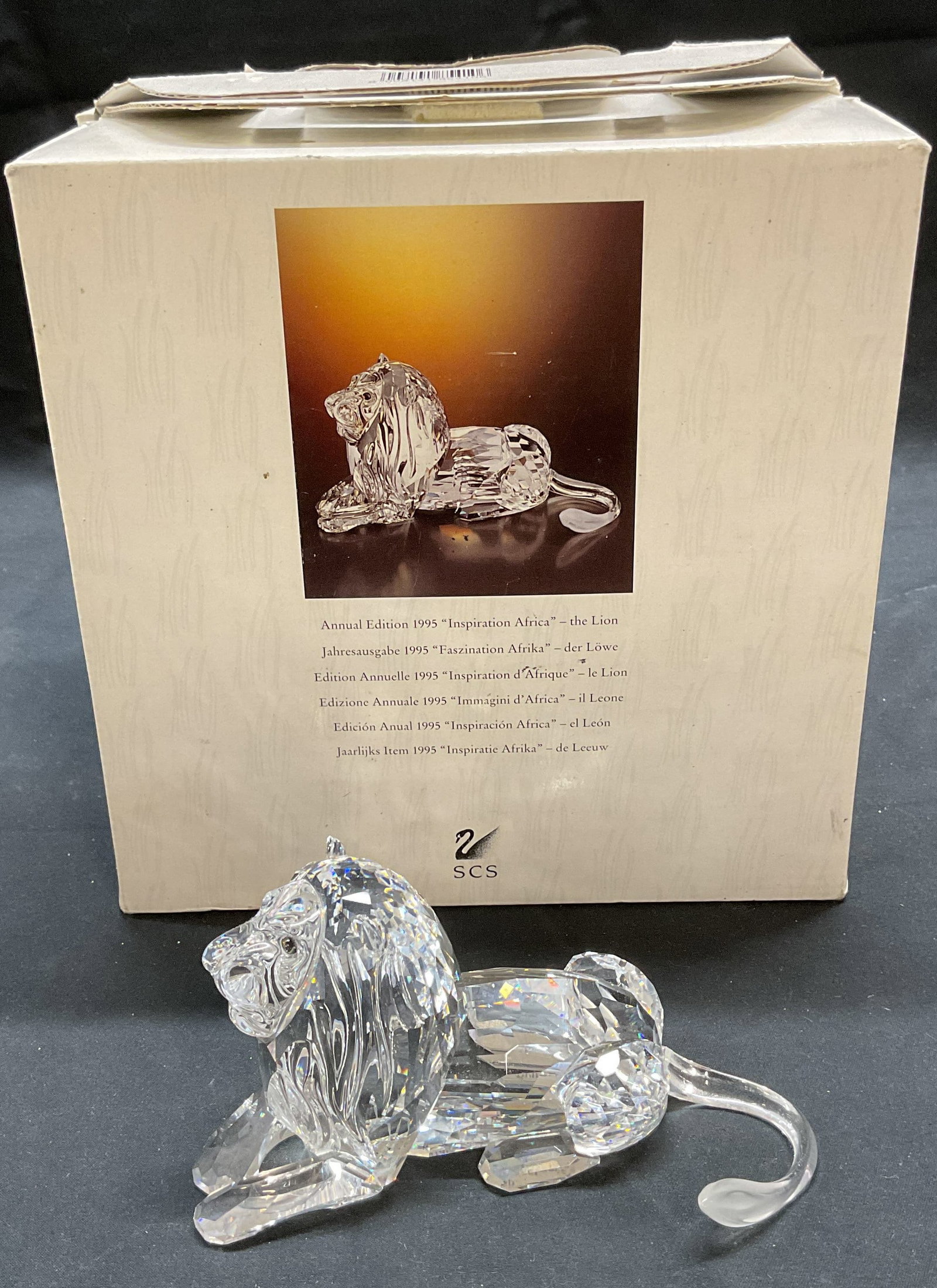 Vtg Swarovski Crystal African Lion Figural: Vintage 1995 Annual Edition Swarovski cut crystal Inspiration Africa Lion figural. Signed on underside. Measures approx 5 x 2.5 x 2.5 inches. Includes original box. Some wear to figural including smal