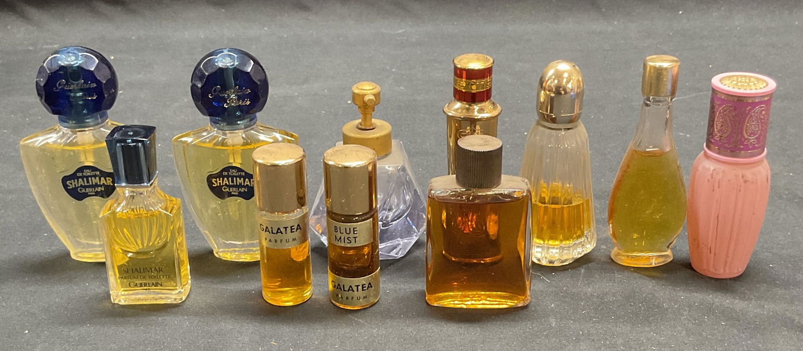Group Vtg Guerlain, FABERGE, Avon Perfume +: Group lot of vintage miniature perfume bottles. Includes SHALIMAR by Guerlain, Fgerette by Faberge, Avon, and more. Largest bottle approx 3.5 inches tall. Some bottles partially full and empty. All pi