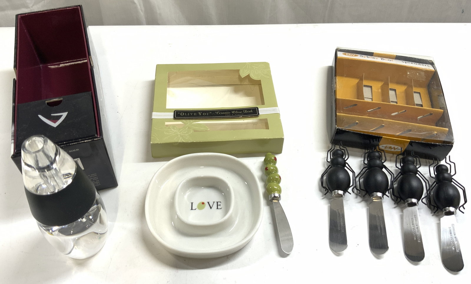 Lot 7 Cheese Knives Olive Dish & Vinturi Aerator: Lot includes 1 wine Aerator with box trademarked VINTURI, 1 Porcelain olive dish and olive handle cheese spreader with box, & 4 Spider handle cheese spreaders with box. Aerator measures approximately 
