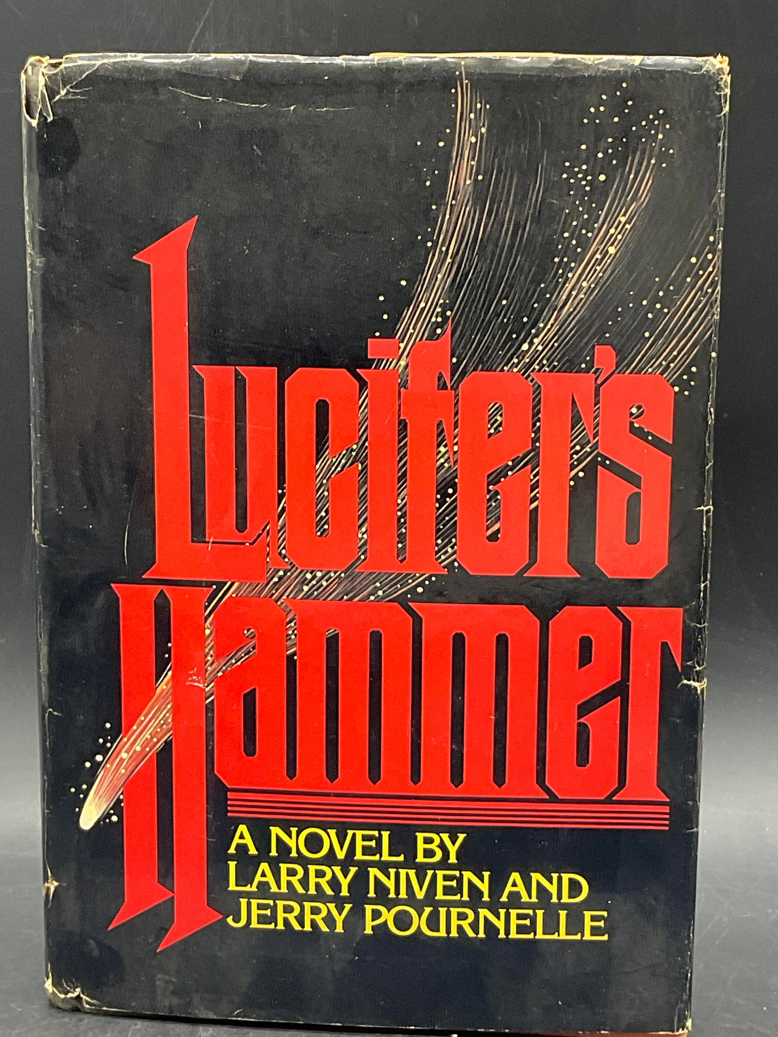 1977 LUCIFERS HAMMER by Larry Niven First Edition: LUCIFERS HAMMER by Larry Niven and Jerry Pourelle. Published by Playboy Press. C. 1977. First edition. Measures approx. 9.5H x 6.75W in. Losses to dust cover, discoloration, and surface wear present. 
