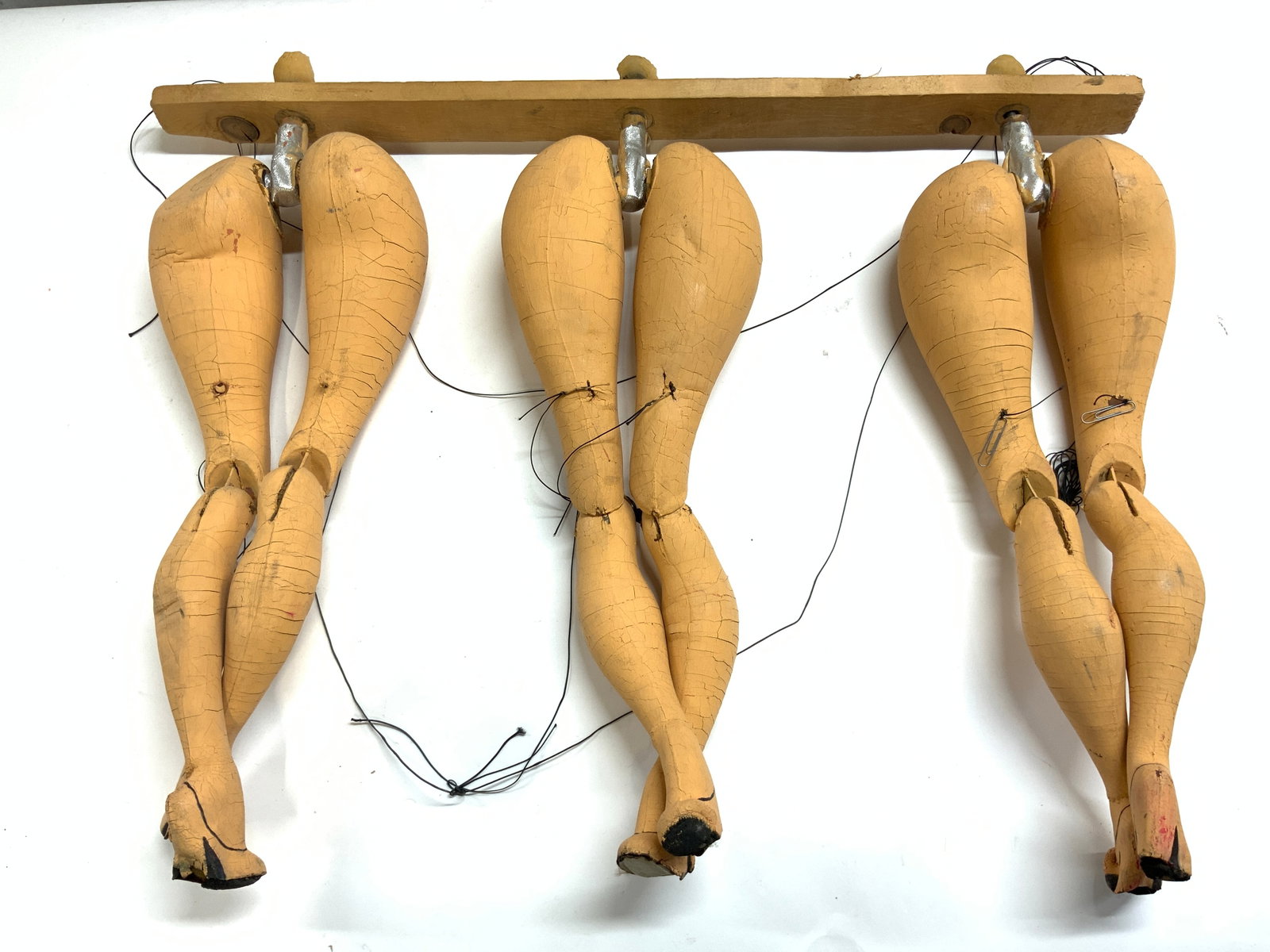 Antq Puppeteer Marionette Rockette Style Legs: Puppeteer marionette legs Appear to be wood and papier-mache. Each pair of legs is tan toned with high heels at feet. Piece has black toned strings. Legs have Rockette style. Measures approx 28 inches