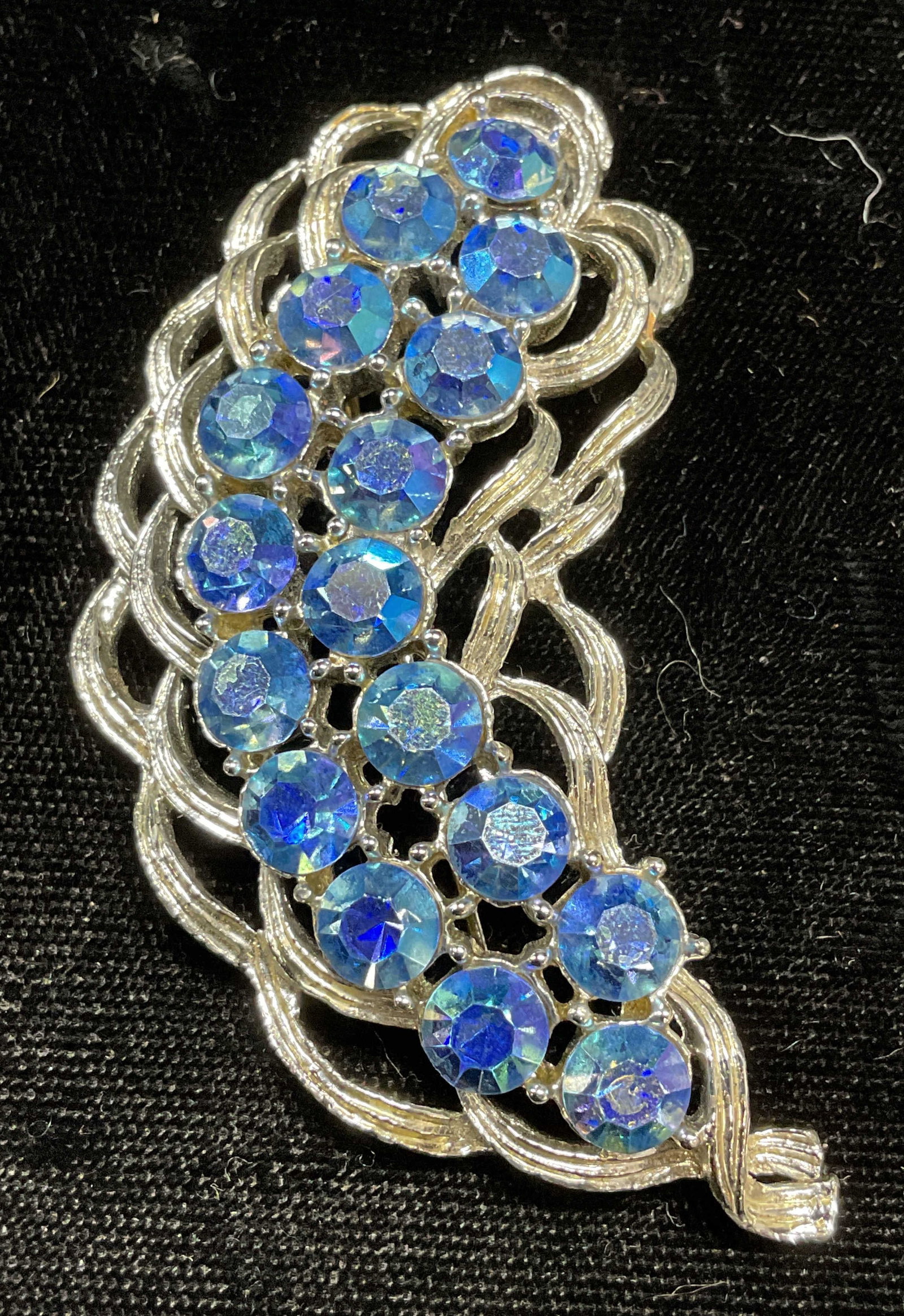 Vintage Silver Tone Blue Crystal Feather Brooch: Vintage silver tone blue crystal feather brooch. Hinge pin on underside. Measures approx 2.75 x 1.5 inches. Some wear including scratching observed. Jewelry, estate jewelry, costume jewelry, cocktail 