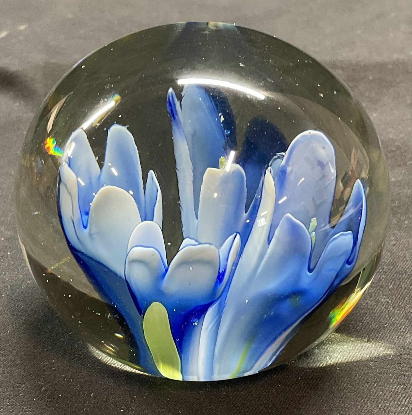 Hand Blown Blue Flower Art Glass Paperweight: Hand blown art glass paperweight with blue flower design. Measures approx 2.25 inches wide. Some scratching observed. Art glass, art glass paperweight, paperweight, flower paperweight, blue paperweigh