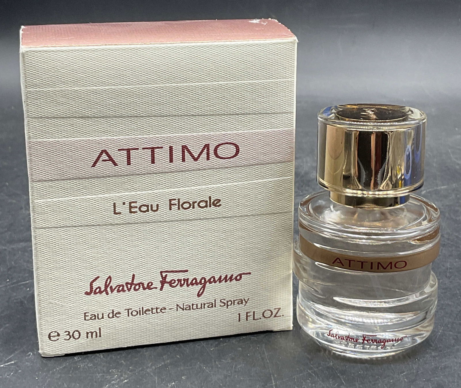 ATTIMO Salvatore Ferragamo L Eau Florale Fragrance: ATTIMO Salvatore Ferragamo L Eau Florale Fragrance Bottle in original box. Bottle is crafted from glass. Lid is crafted from gold tone and colorless plastic material. Liquid to the interior of the bot