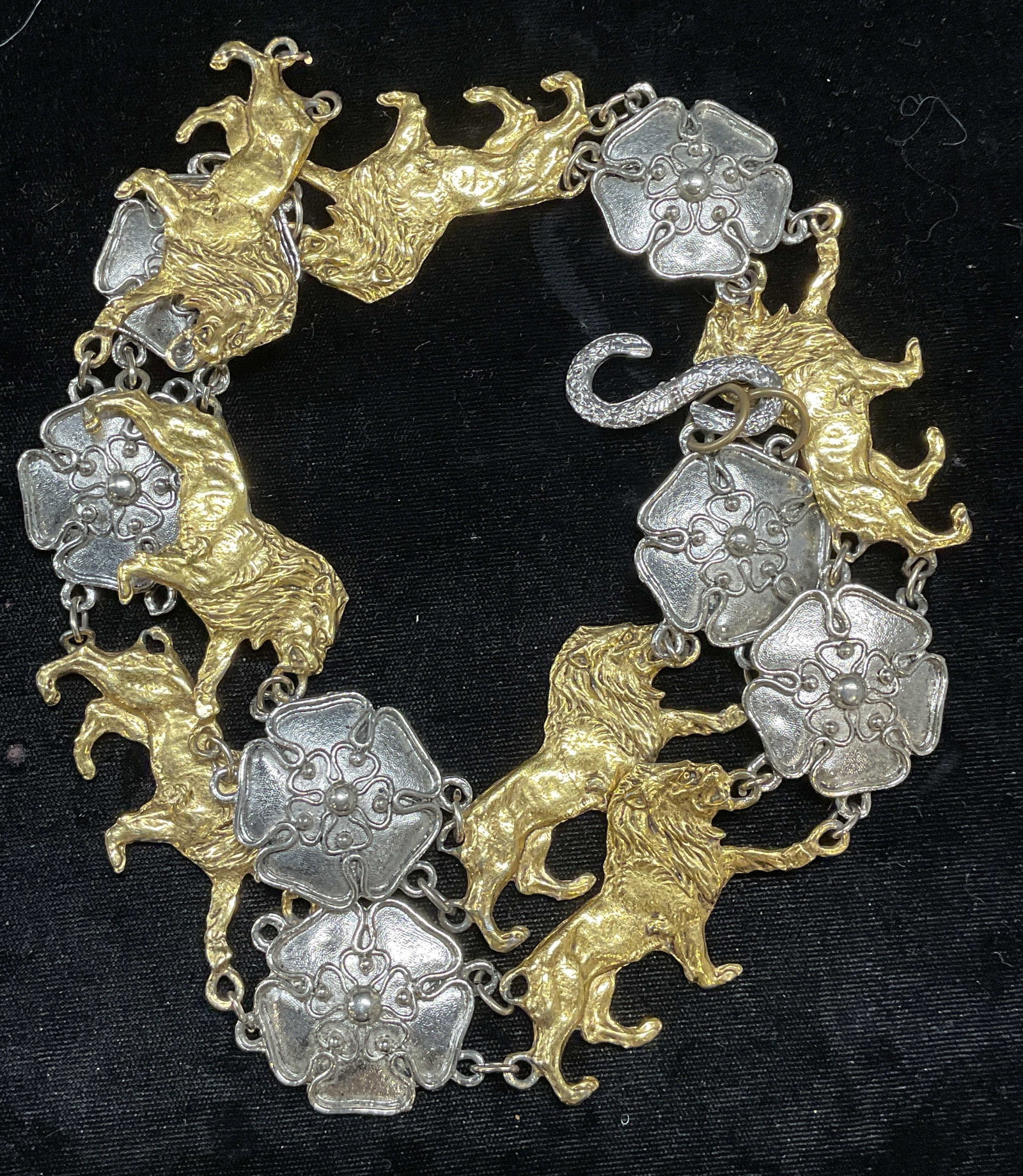 Silver & Gold Tone Lion & Flower Belt: Silver and gold tone metal belt with lion and flower motif pendants. Measures approx 28 inches long. Links need replacement. Some wear including scratching observed. Belt, lion belt, flower belt, silv