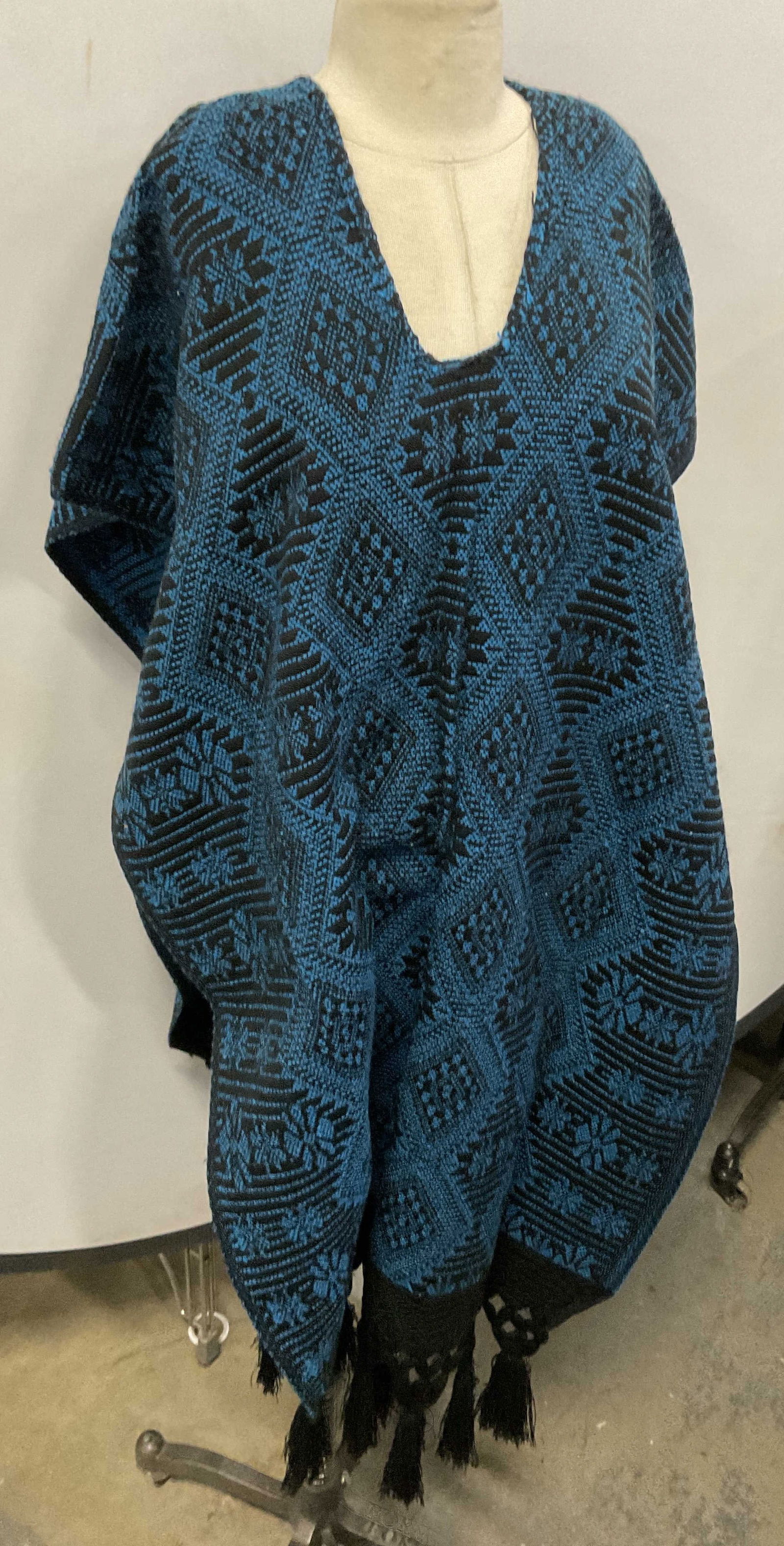 Vintage Blue & Black Patterned Poncho Shawl: Vintage Blue & Black Patterned Poncho Shawl. Slits in the sides. Tassel detail towards the base. Crafted from soft hand fabric. Measures approx. 49L x 23.5W in. Measured flat. Surface wear, residue, a