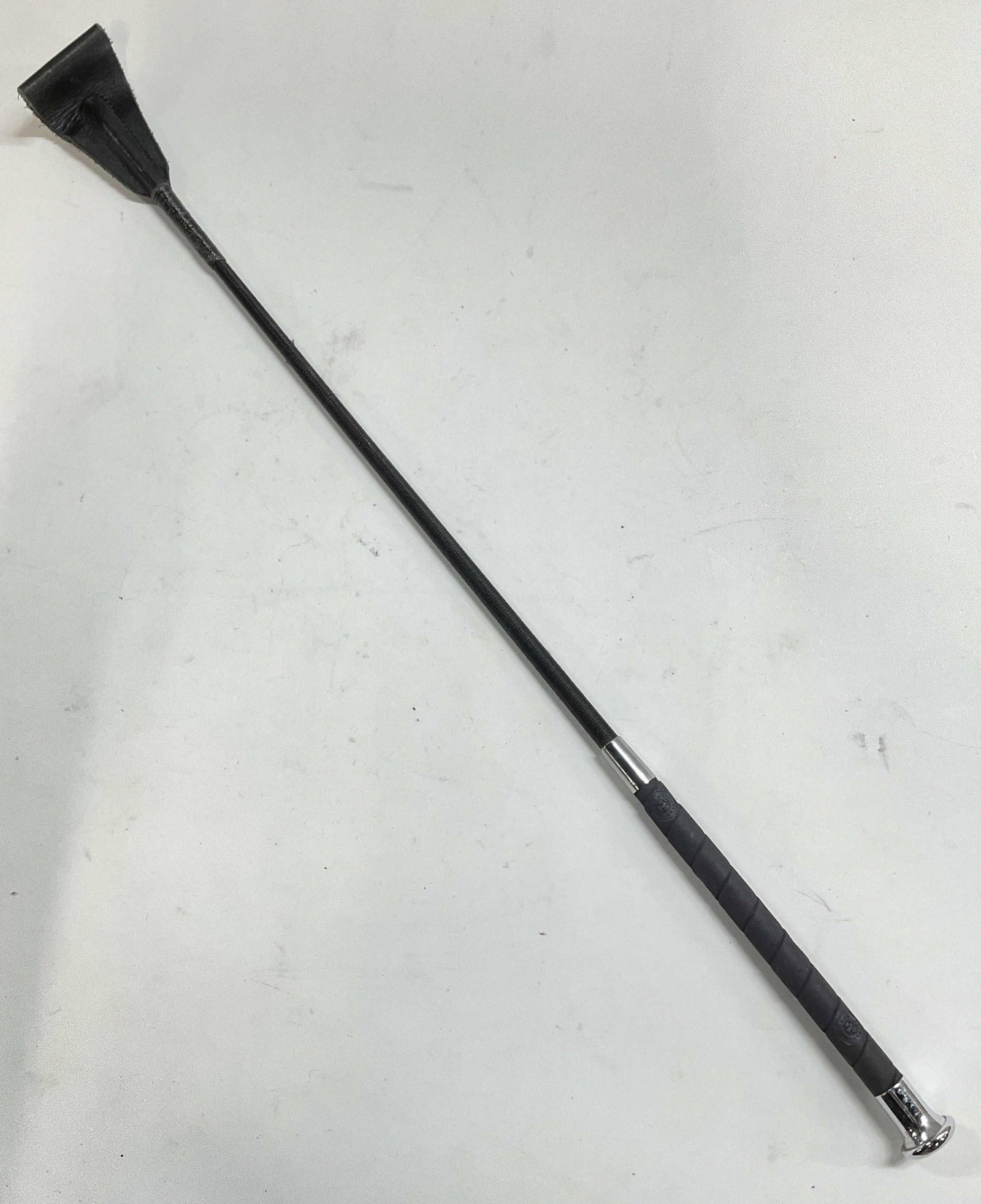 Fleck Germany Black Riding Crop: Fleck Germany black riding crop. Leather, cord, and synthetic material. Signed on handle. Measures approx 24.5 inches long. Wear including scratching observed. Fleck riding crop, fleck Germany, riding