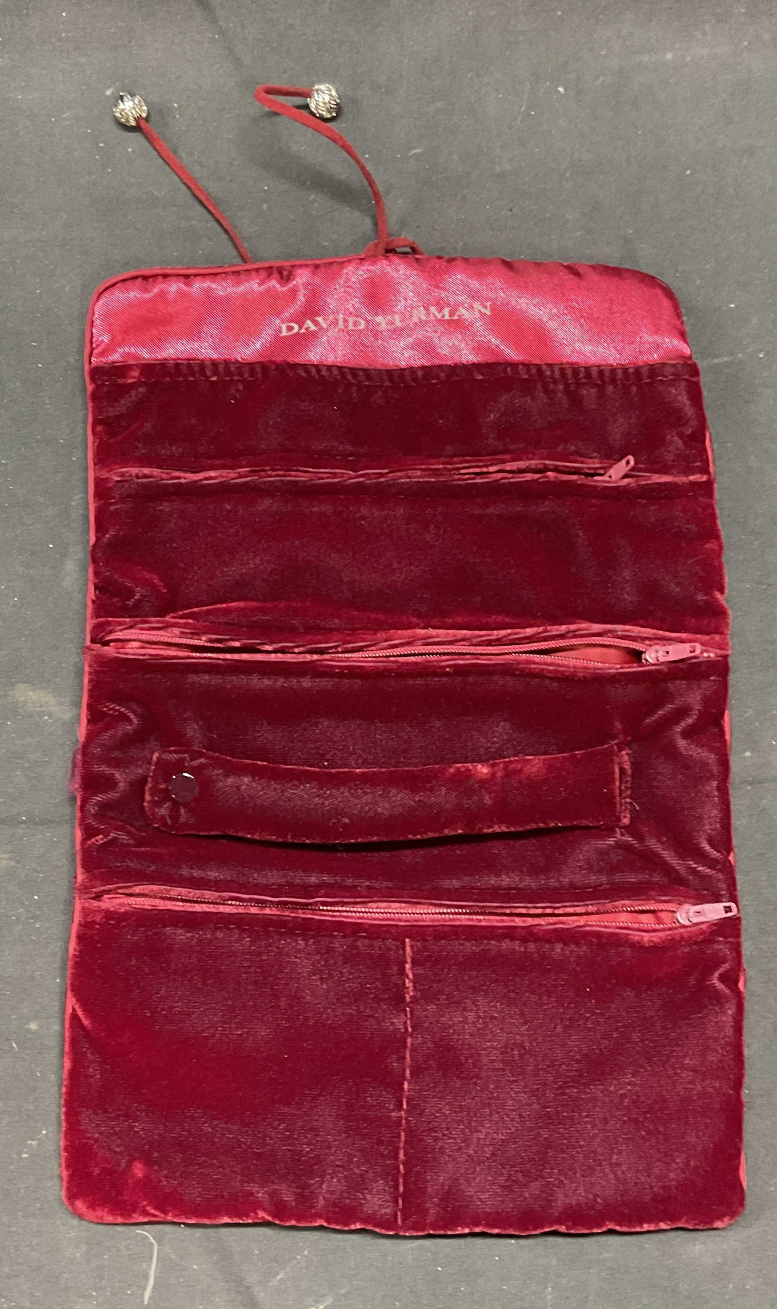 David YURMAN Burgundy Velvet Jewelry Storage Pouch: David YURMAN burgundy velvet jewelry storage pouch. Multiple interior pockets with zippers. Satin lined pockets. Fold up pouch with two cords and silver tone beads. Signed on interior. Total dimension