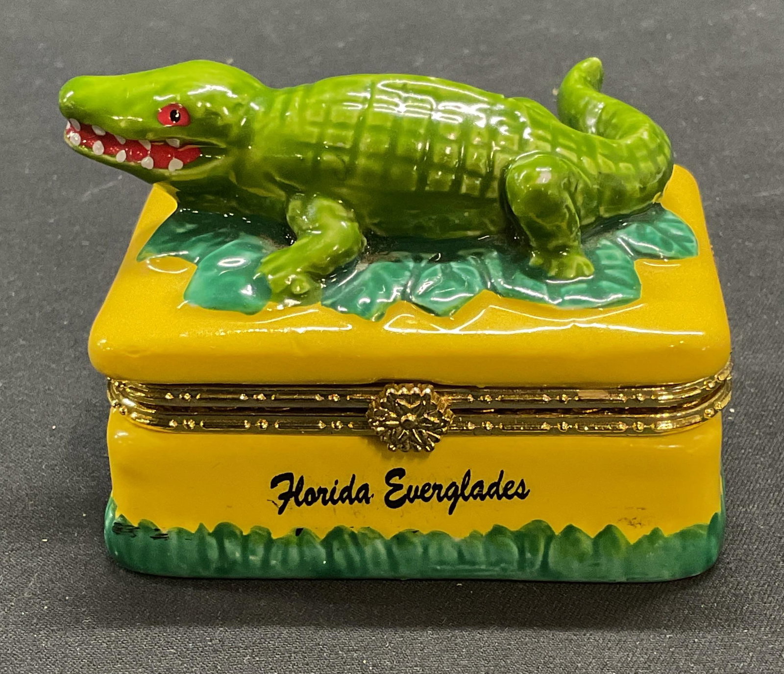 AGiftCorp Florida Alligator Porcelain Trinket Box: AGiftCorp Florida Everglades souvenir porcelain trinket box with alligator motif. Hand painted. Measures approx 2.75 x 2 x 2 inches. Some scratching observed. Trinket box, porcelain trinket box, allig