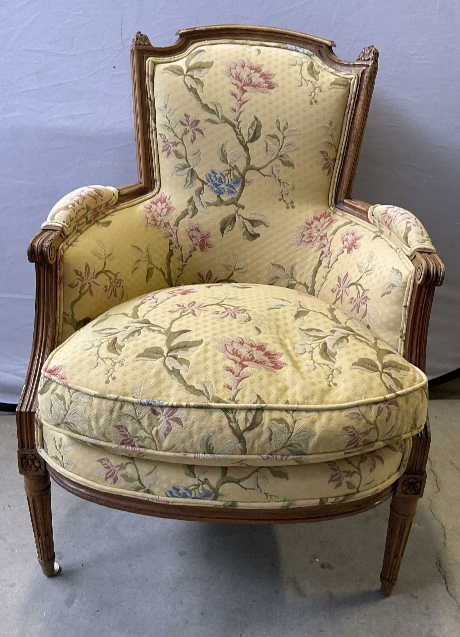 Vintage Louis XV Style Upholstered Armchair: Vintage Louis XV Style Upholstered Armchair. Yellow hued upholstery with multicolored florals to the piece. Carved woodwork accents and scrolled arms. Taper to the legs. Removable seat cushion. Measur