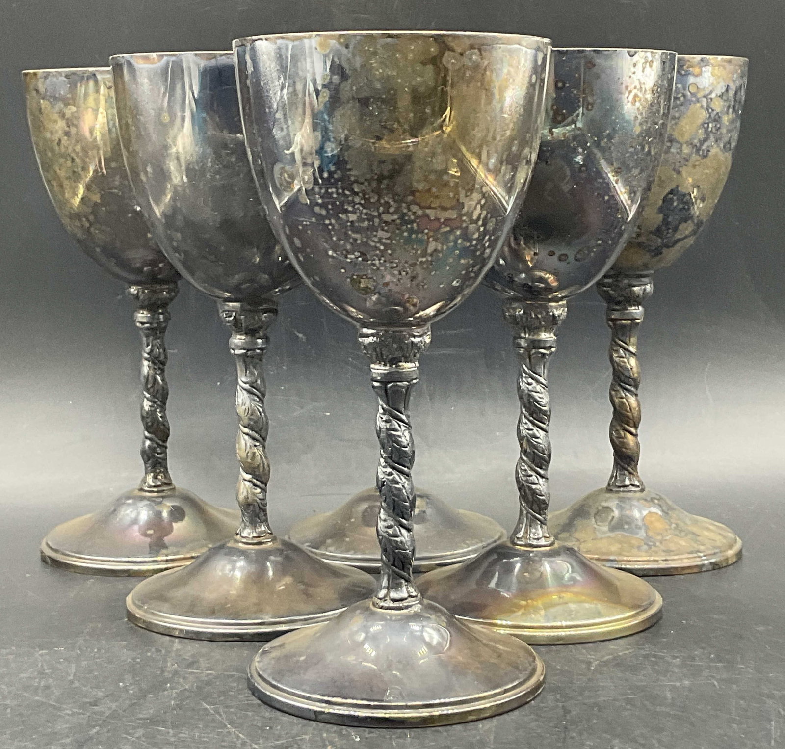 6 Trdmrkd Silver Plate Twisted Stem Goblets Spain: A set of six Trademarked Silver Plated Twisted Stem Goblets. Undersides are trademarked and read SPAIN. Measures approx. 7H x 3.25W in. Discoloration and surface wear present. home decor, home accents