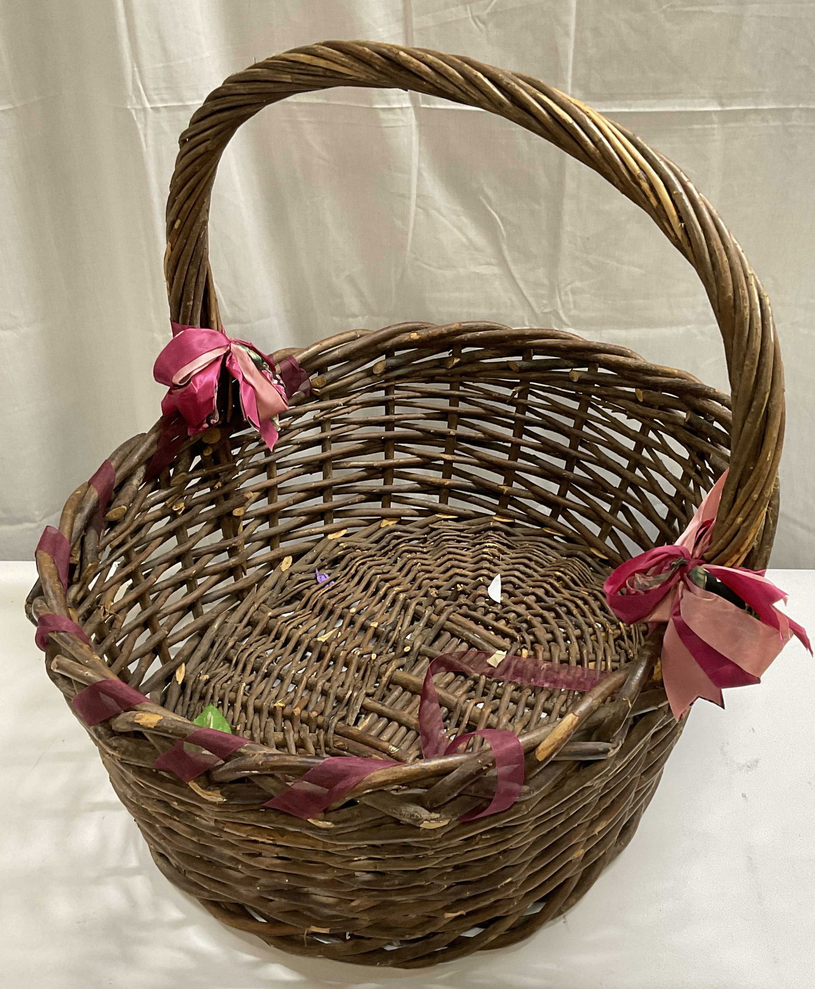Handled Woven Basket W/ Ribbon Accent, 21.5in Ht: A Handled Woven Basket. Crafted from natural material and fabric ribbon. Measures approx. 25D x 20W x 21.5H in. Losses to material and surface wear present. Detritus to interior. home decor, home acce