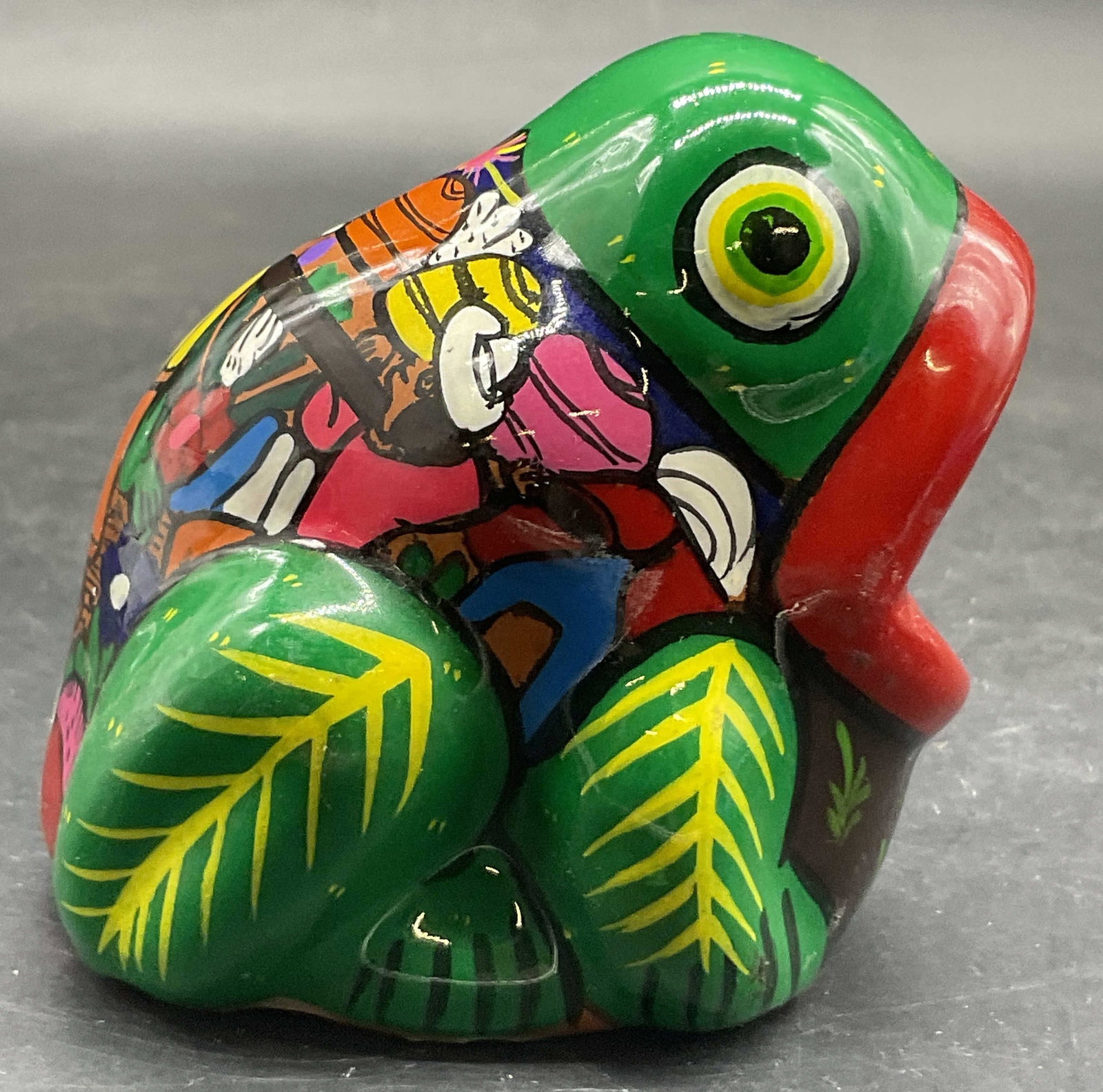 Vintage Hand Painted Pottery Frog Figural: Vintage Hand Painted Pottery Frog Figural. Measures approx. 3H x 2.5W in. Multicolored designs to the frog. Reverse features a figural motif. Surface wear consistent with age, use, and exposure. Chipp